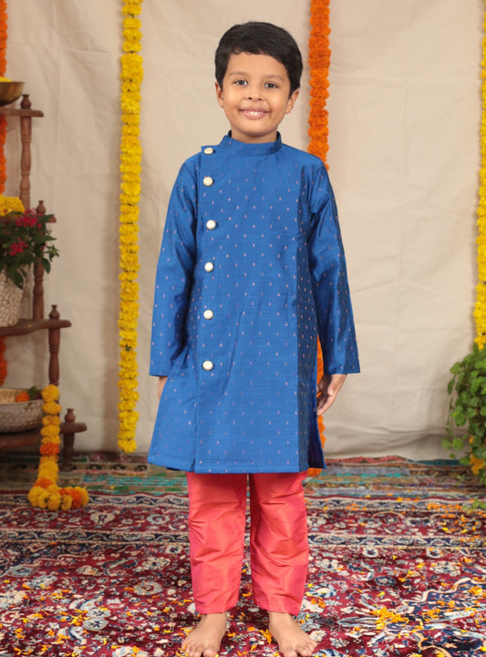 Royal blue pine silk Bandh Gala kurta with side placket and carrot pink cotton silk salwar set.Kurtas with collar or Angrakha pattern teamed with salwar are the best choice for any festive occasion for boys. They are Trendy, Easy to wear and comfortable to carry.