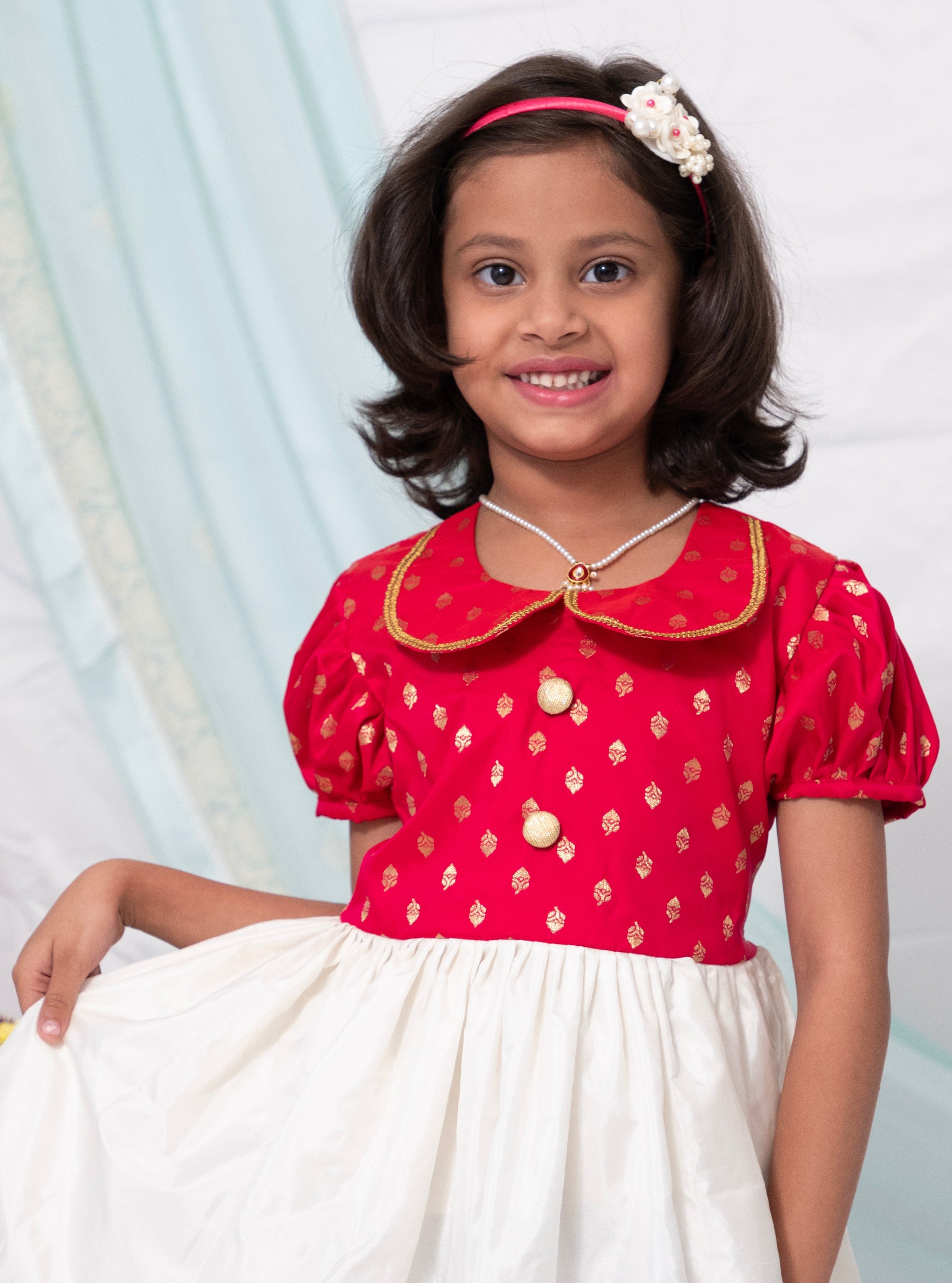 Fuschia brocade silk and Ivory Mysore silk dress with Peter pan collar and puffed sleeves for Girl.Let your princess be as comfortable as in her casuals with carefully designed & crafted Comfort Ethnic Wear by Soyara Ethnics. Keep her fashion quotient high with timeless patterns, vibrant combinations and royal textiles.