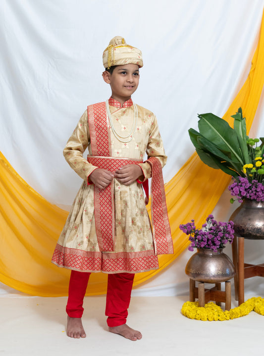 Beige Banarasi Brocade Peshwai Dress with Red cotton silk churidar salwar for Batu. Comes with a coordinated Shela and adjustable Waist belt for a perfect Reception look! This Set is ideal for rituals like Matrubhojan,Muhurt during Munj/Upanayan/Vratabandha/Thread Ceremony.