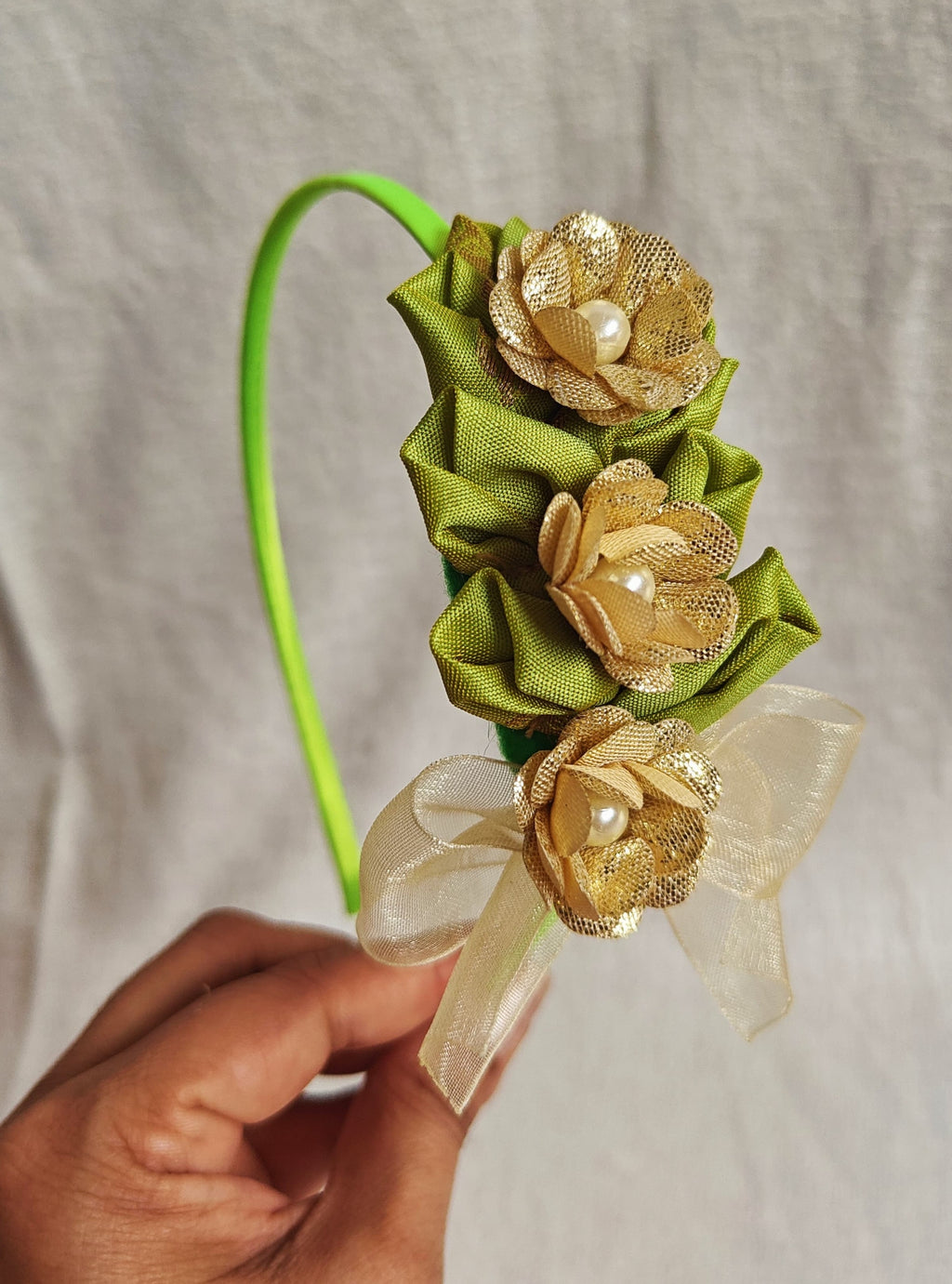 This parrot green headband for girls features delicate fabric flowers and is handcrafted with great care. It is ideal for girls over the age of 2 and makes a lovely addition to any outfit.