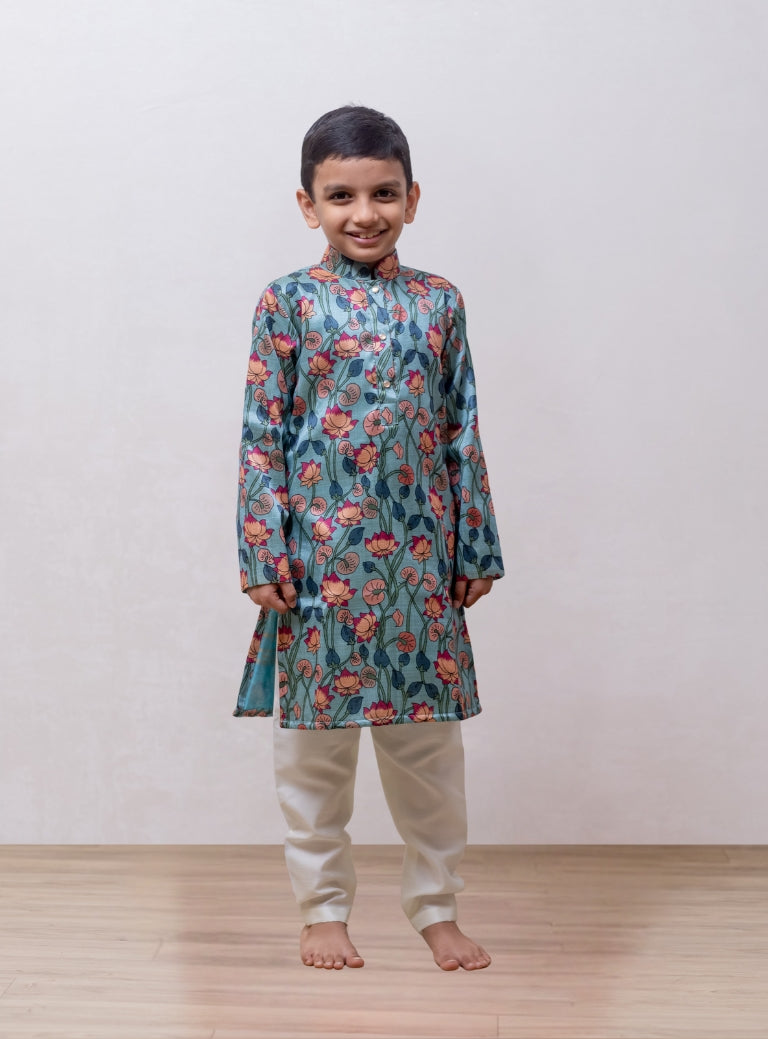 This Greish Sky blue tussar silk kurta features a lotus print and a stand collar accented with stone buttons. It is lined with cotton on the inside to provide enhanced comfort and superior quality.