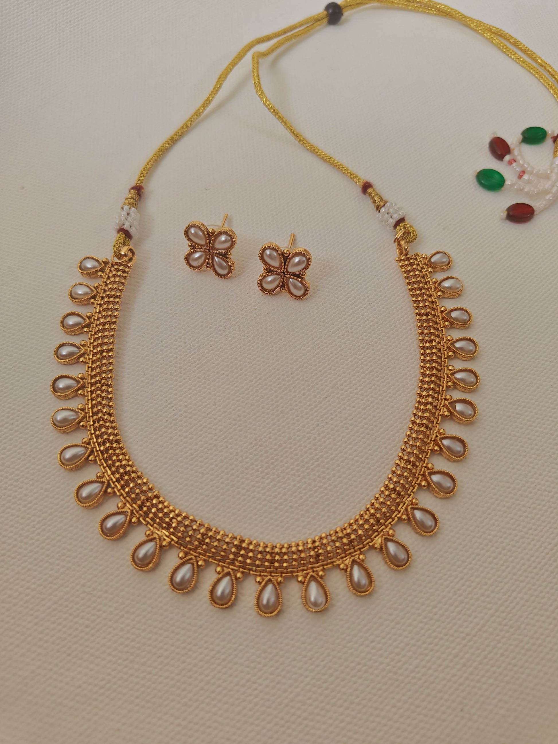 Pearls studded choker with matching earrings for Girls.This set includes a choker and matching earrings with studded pearls, perfect for girls. The drawstring allows for easy length adjustment.