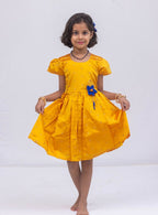 This stunning dress is made of yellow taffeta silk and features elegant puff sleeves. The dress also includes a delicate handmade fabric flower brooch, adding a touch of sophistication. A matching blue hair clip is included for a coordinated look.