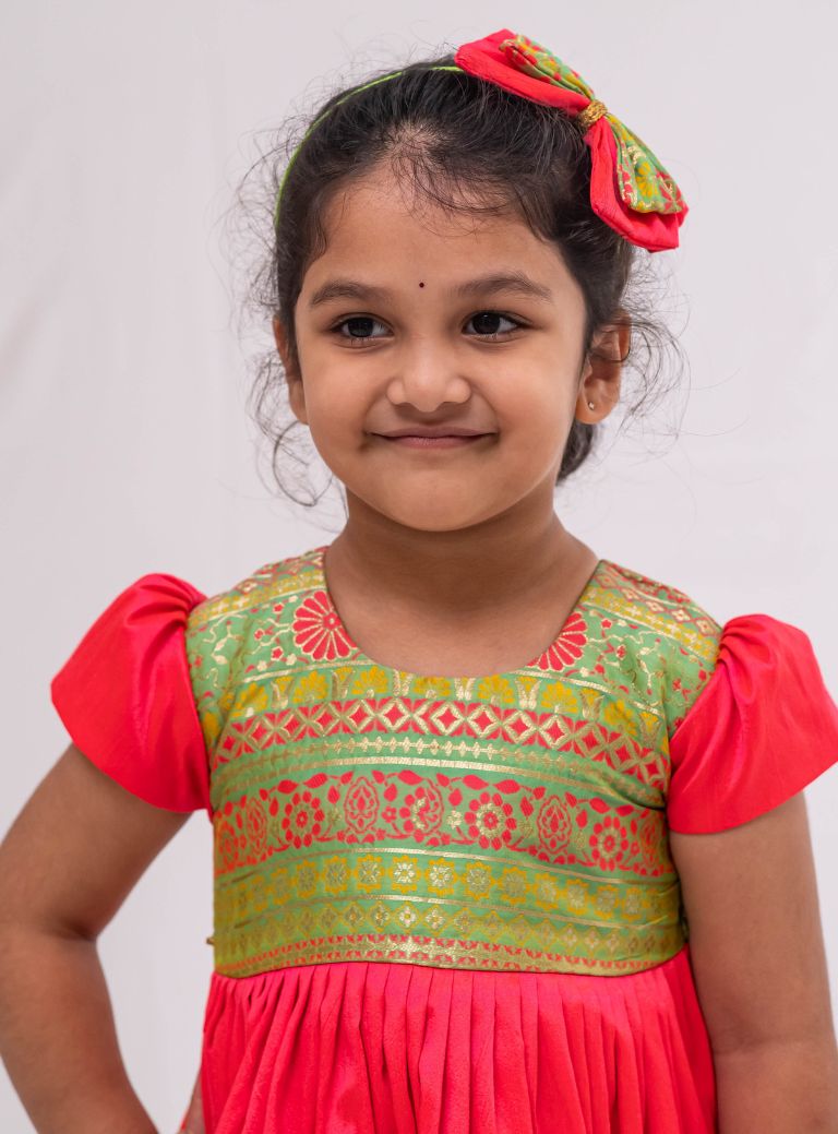 Neon green banaras brocade with candy pink raw silk flared cap sleeved dress for Girls. Elevate any occasion with this unique piece.Let your princess be as comfortable as in her casuals with carefully designed and crafted Comfort Ethnic Wear by Soyara Ethnics. 