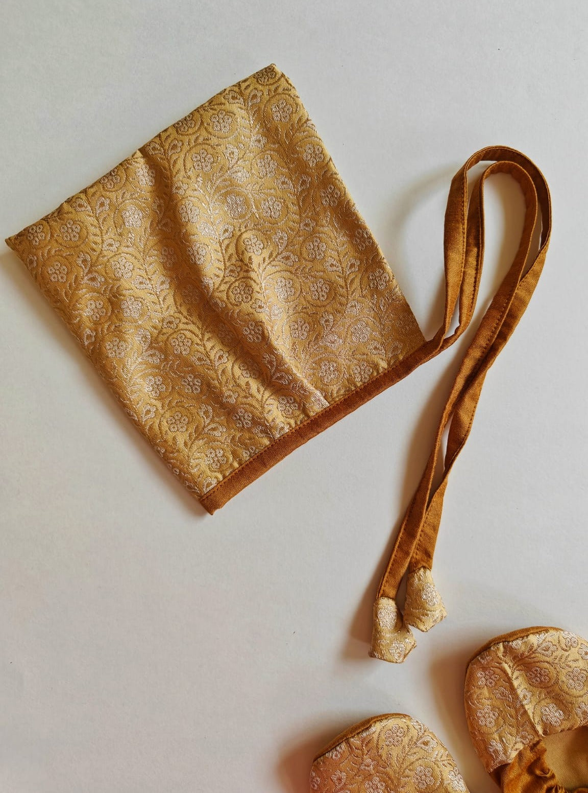 Golden Paithani Naming Ceremony Combo for Baby Boy includes Bonnet,Booties.Golden brocade bonnet,paithani booties,fabric headbands all these Handcrafted accessories for Newborn are perfect add ons to any traditional attire of the baby.Designer baby mats,set of generic bloomers are other naming ceremony essentials.