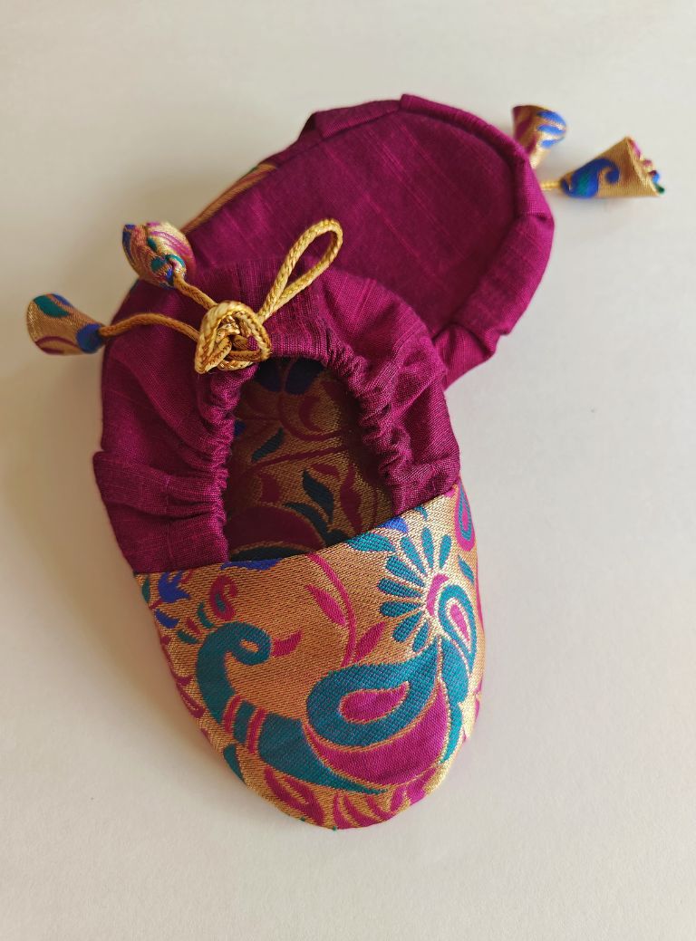 Magenta Peacock Paithani Motif, adjustable unisex Newborn Baby Mojaris /Booties.Paithani motif unisex booties for baby. Team these with any ethnic dress and complete the royal look! Completely made out of fabrics inside out , make these booties perfectly comfy first ethnic wear for the newborn.