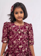 This Dark Plum banaras brocade ghagra is complemented by a Peterpan collared mutton sleeved choli.Let your princess be as comfortable as in her casuals with carefully designed & crafted Comfort Ethnic Wear by Soyara Ethnics.Keep her fashion quotient high with timeless patterns, vibrant combinations and royal textiles.