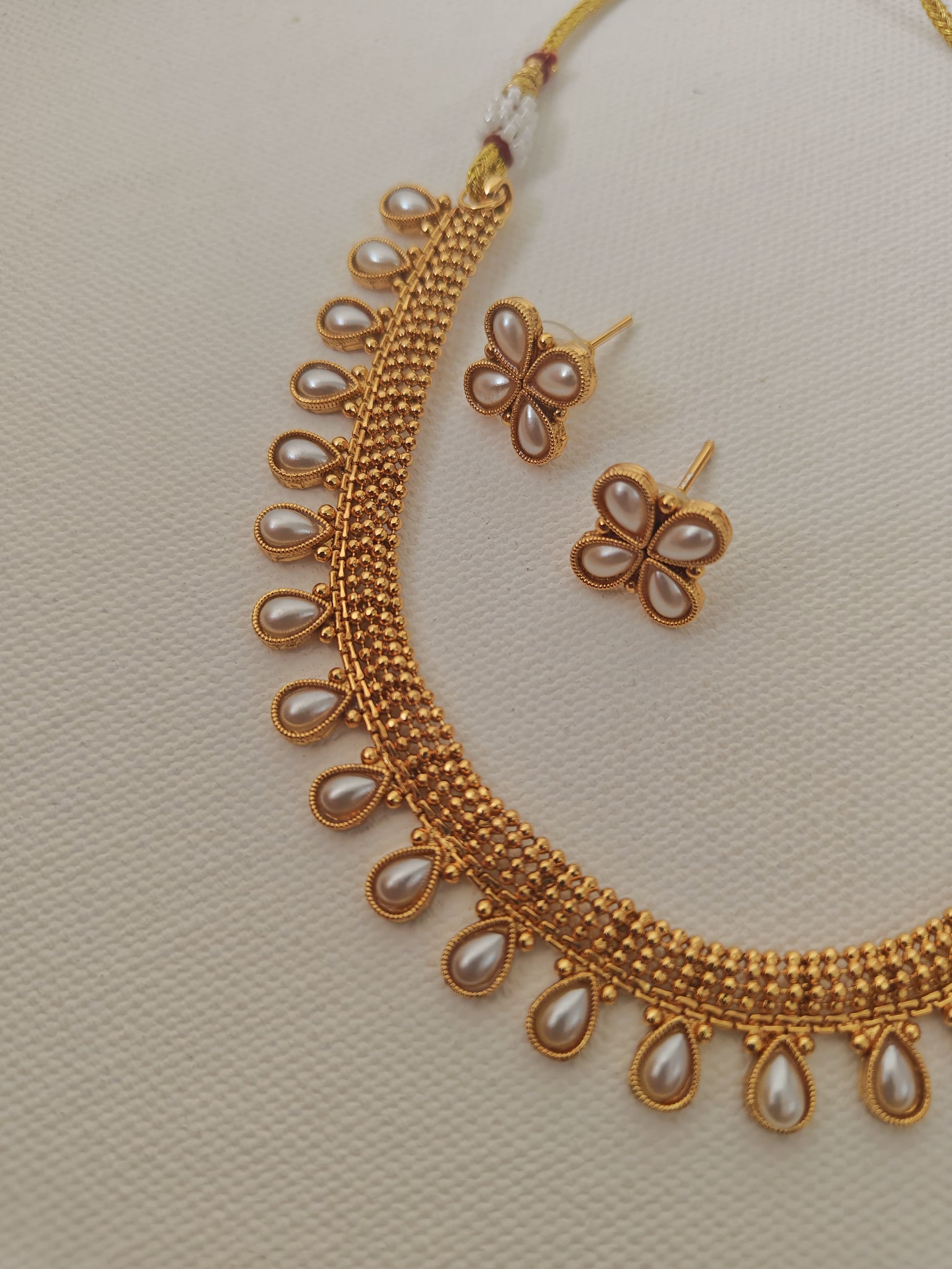 Pearls studded choker with matching earrings for Girls.This set includes a choker and matching earrings with studded pearls, perfect for girls. The drawstring allows for easy length adjustment.