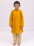 This Mustered Yellow kurta for boys features a knife pleated design crafted from raw silk. Adorned with jari buttas, it boasts a stand collar and front placket opening for a sophisticated touch. The cotton lining on the inside ensures comfort and quality.