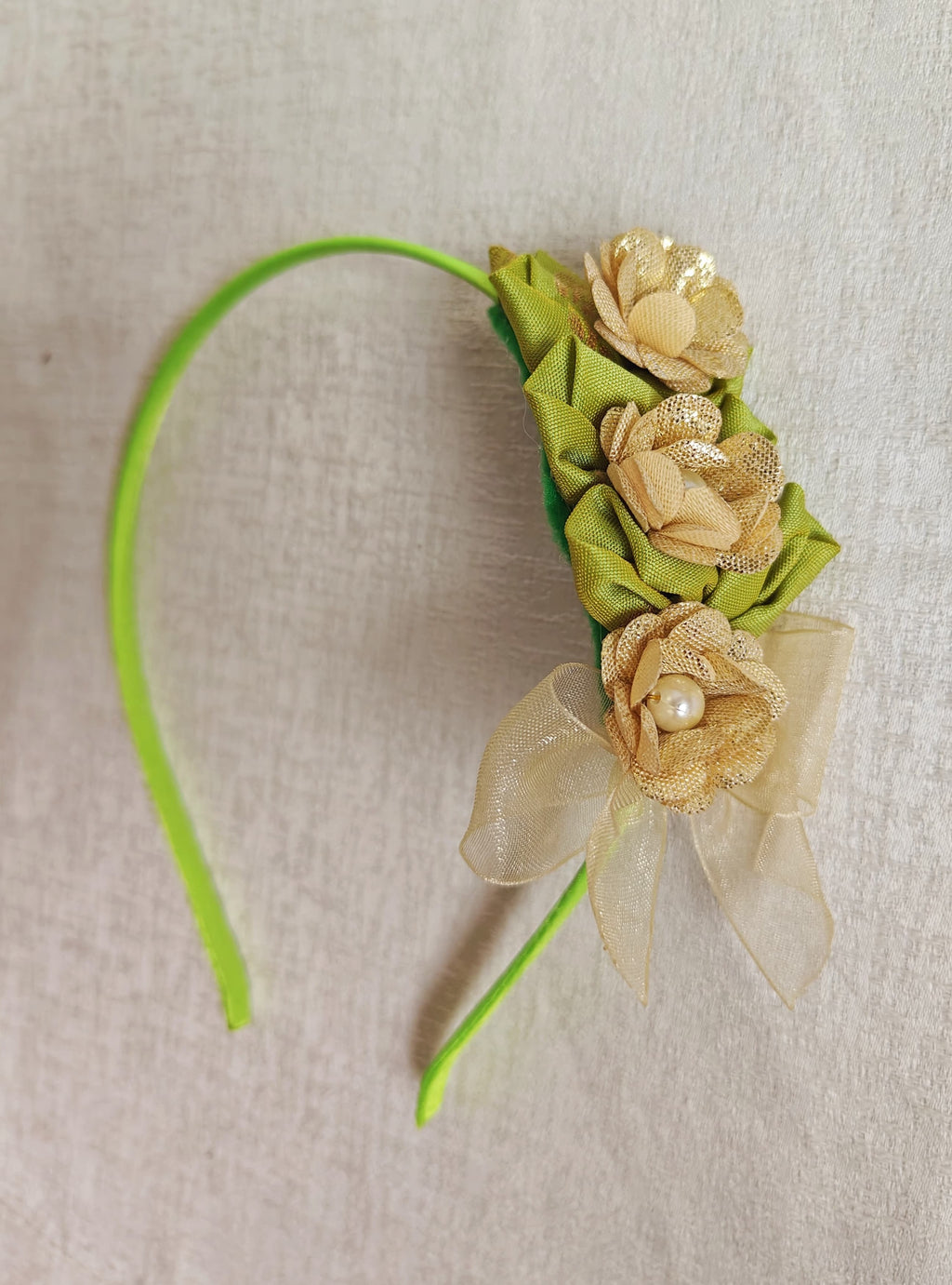 This parrot green headband for girls features delicate fabric flowers and is handcrafted with great care. It is ideal for girls over the age of 2 and makes a lovely addition to any outfit.