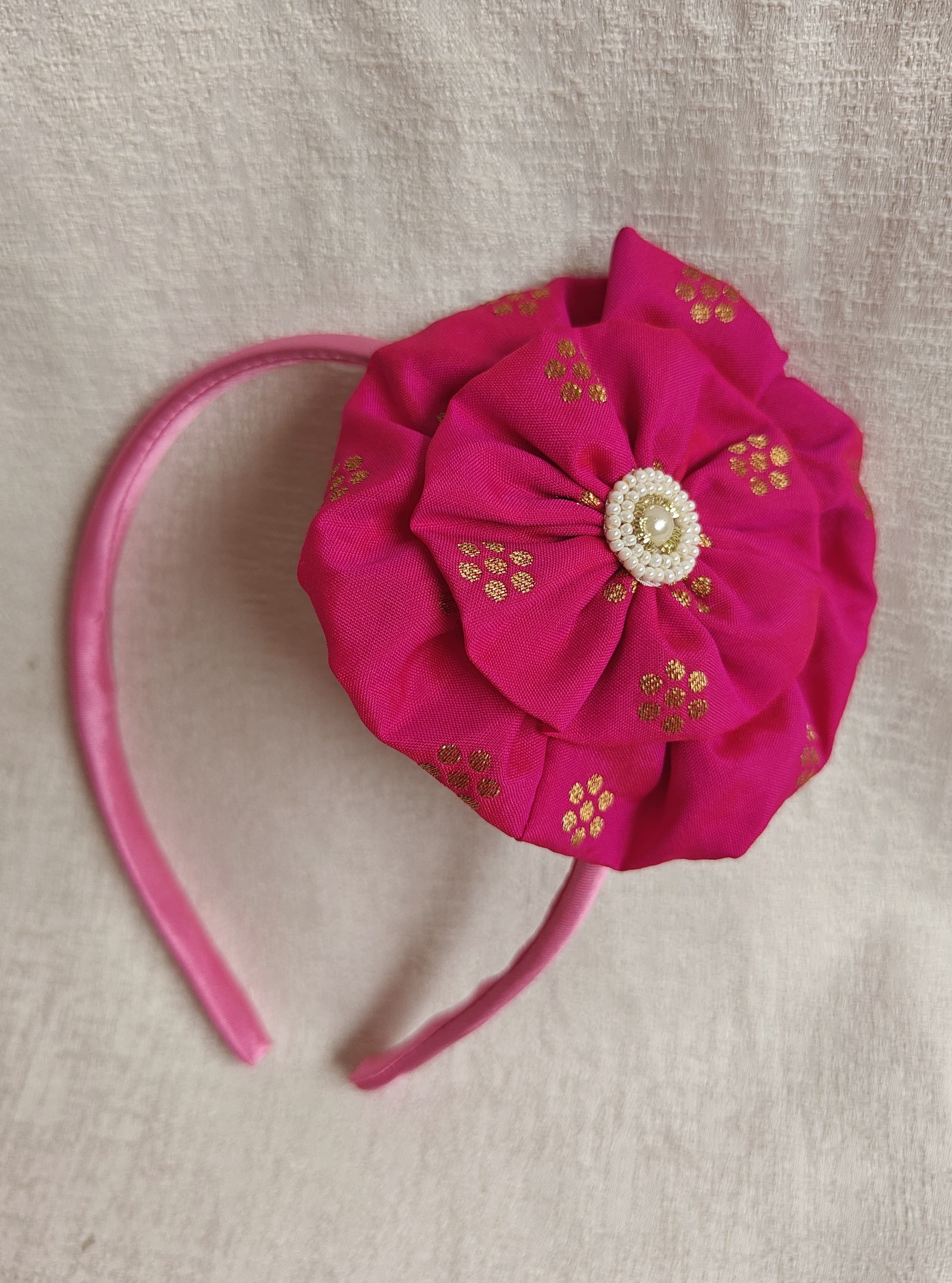 This Dark pink Big Handcrafted fabric flower headband with pearls embellishment for Girls is expertly crafted with immense love and suitable for girls above the age of 2 years. The intricate handwork and delicate pearl detailing make it a standout accessory for any young girl.