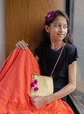 The Magenta and Navy Blue Purna set features a flower motif headband, necklace, earrings, and a coordinated sling purse. The necklace is crafted from high-quality glass beads with gold-plated accents. The golden raw silk sling purse is equipped with a gold-toned metal zipper for secure closure.