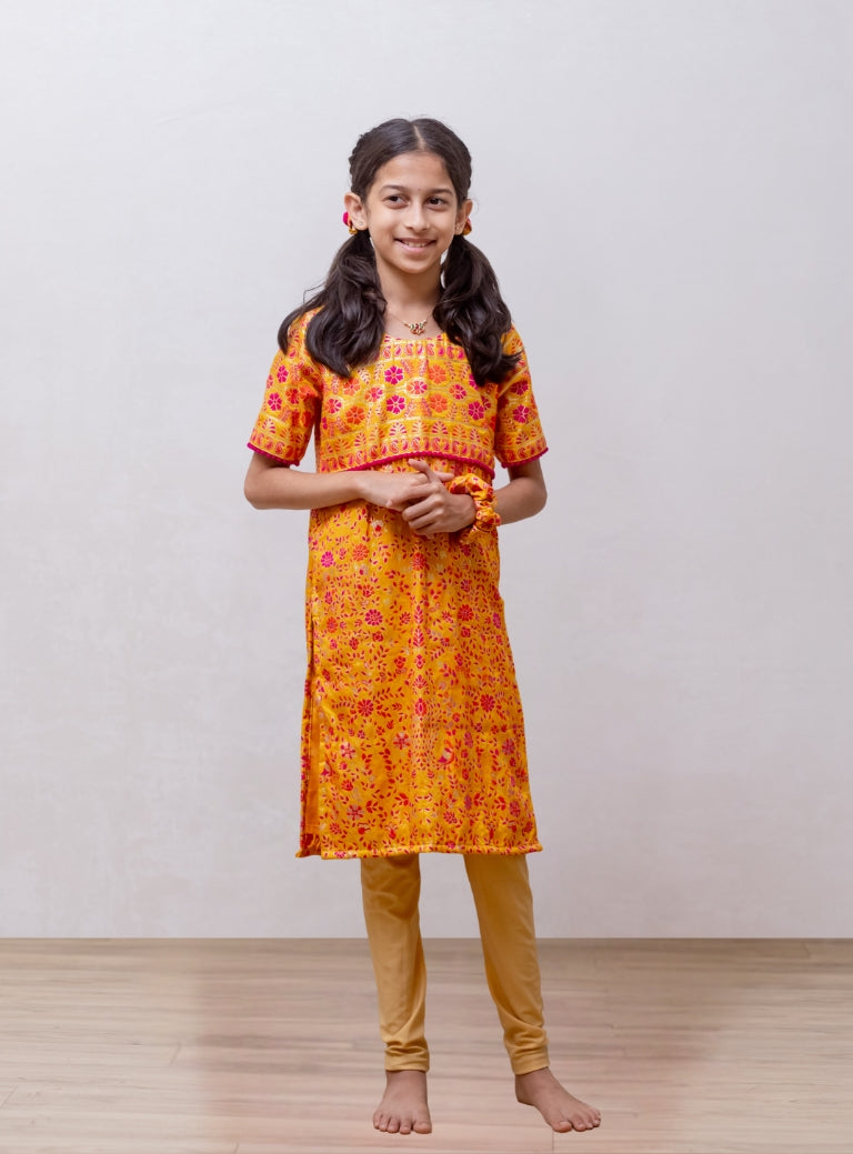 Yellow soft silk banaras brocade kurti with yoke pattern embellished with contrast pompom lace for Girls