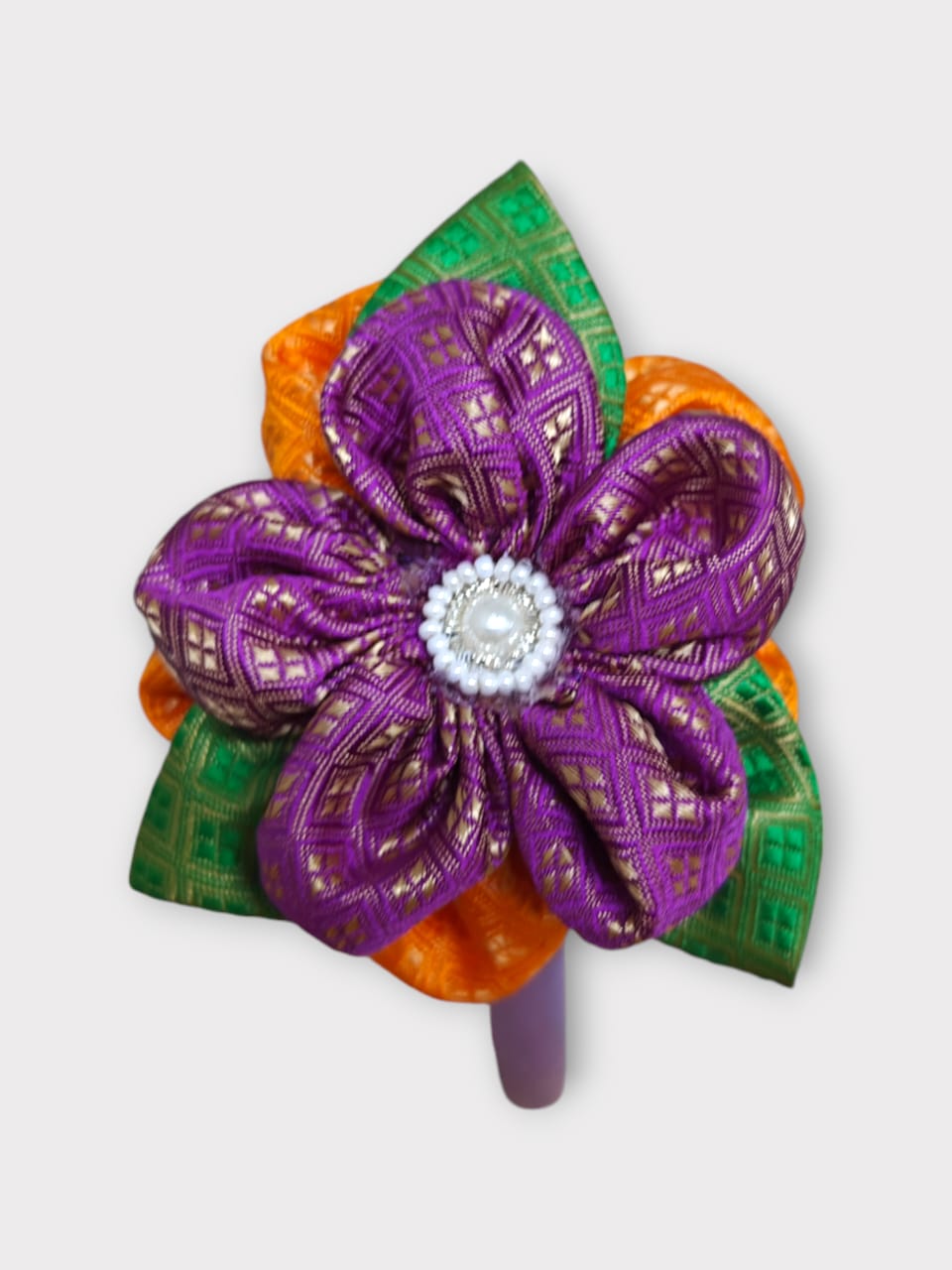 Magenta brocade layered flower motif , satin wrapped plastic hairband for Girls.This magenta brocade hairband features a layered flower motif and is wrapped in satin-covered plastic. It is perfect for girls aged two and up, making it a charming accessory for any outfit.