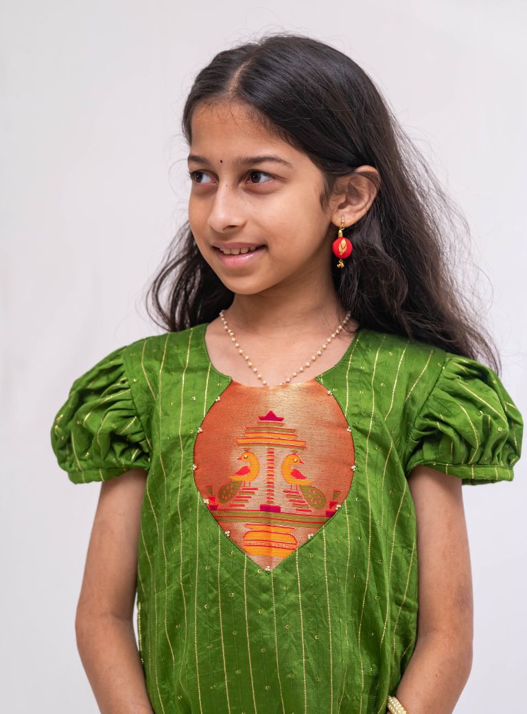 Olive green satin chanderi sequined, puff sleeved kurti with paithani yoke pattern for Girls.Let your princess be as comfortable as in her casuals with carefully designed & crafted Comfort Ethnic Wear by Soyara Ethnics.Keep her fashion quotient high with timeless patterns, vibrant combinations and royal textiles.