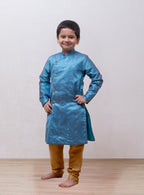 This boys' kurta features a Steel Blue mulberry silk fabric with a front open stand collar and distinctive stone-studded buttons. It is paired with a Golden Banglori silk salwar, and the kurta includes a comfortable cotton lining for added comfort.