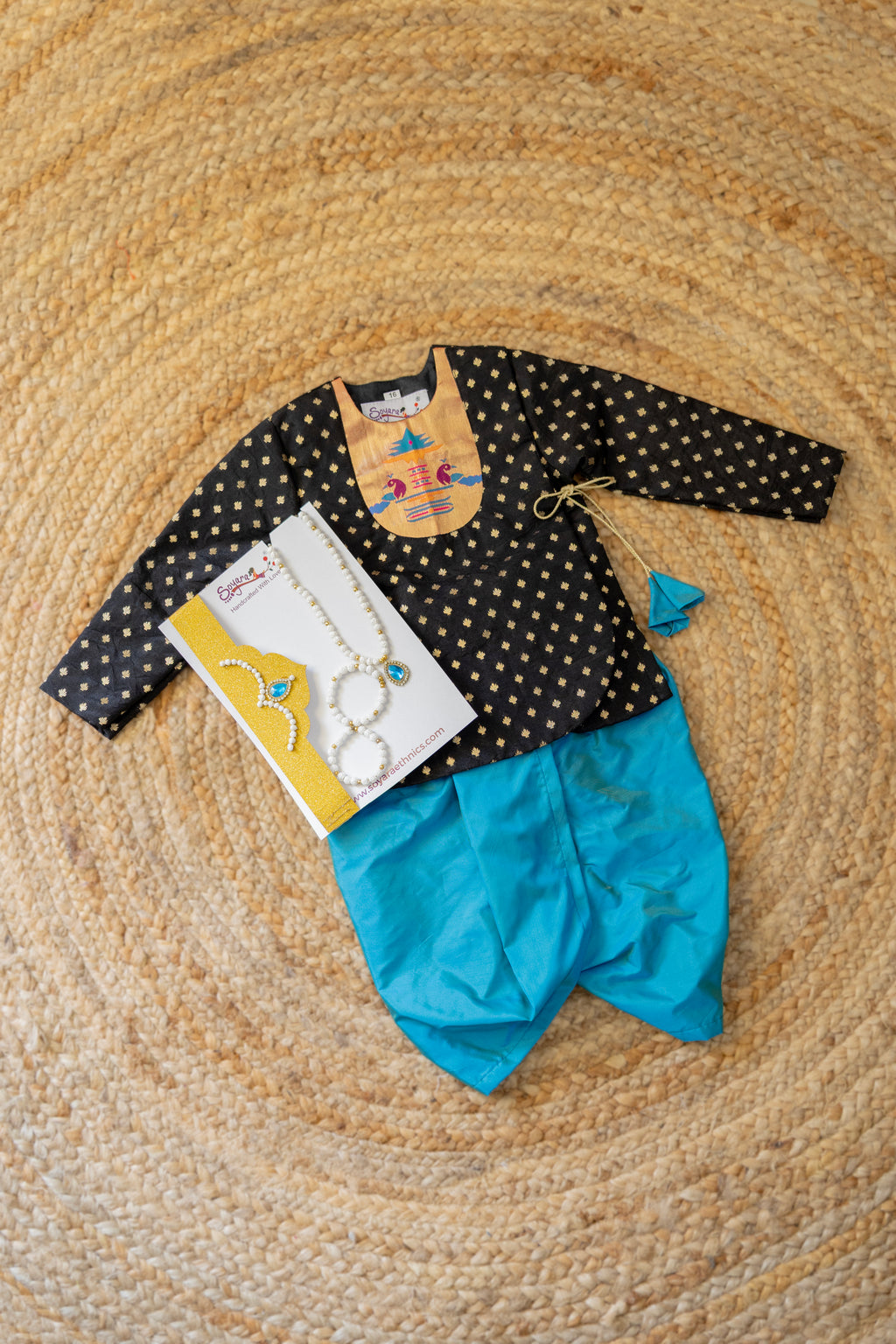Black brocade silk front kurta with paithani motif yoke and matching tassels and teal blue malai silk dhoti for new born