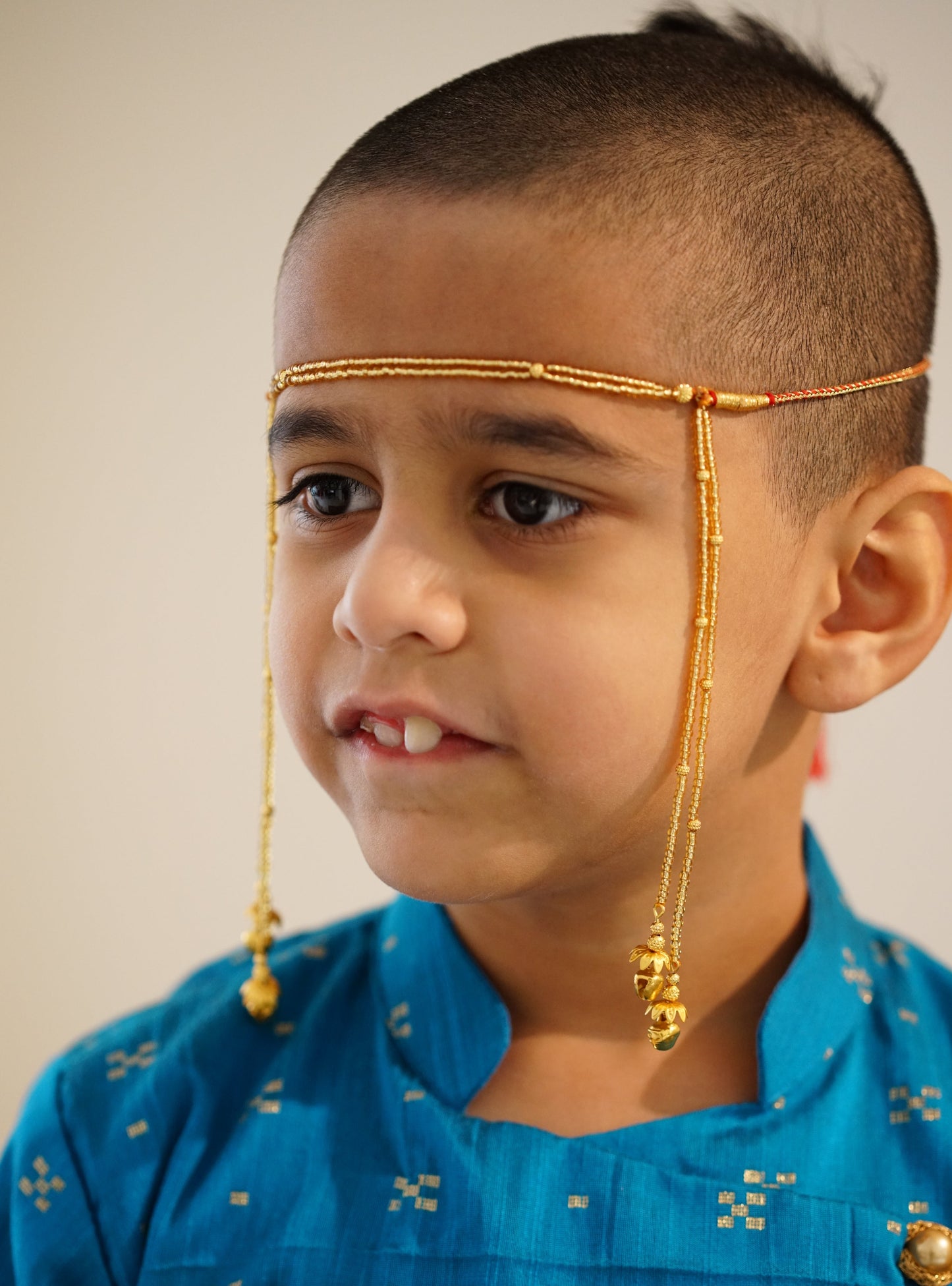 Mundavalya is a forehead ornament worn by Batu for Vratabandh/Munj/Upnayan/Thread Ceremony. Mundavalya,kanthi,bhikbali,topi,pagdi are boys accessories exclusively designed using Pearls,glass beads,jadau & gold plated findings for Batu,for Upanayan/Vratabandha/munj /thread ceremony.