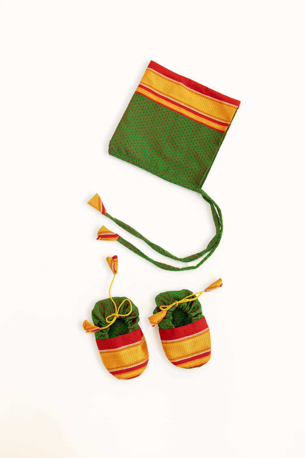 Green handloom khunn with red border topda / topi/ bonnet with coordinated khunn booties set for NewBorn. Handcrafted accessories for Newborn are perfect add ons to any traditional attire of the baby.Designer baby mats,set of generic bloomers are other naming ceremony essentials.