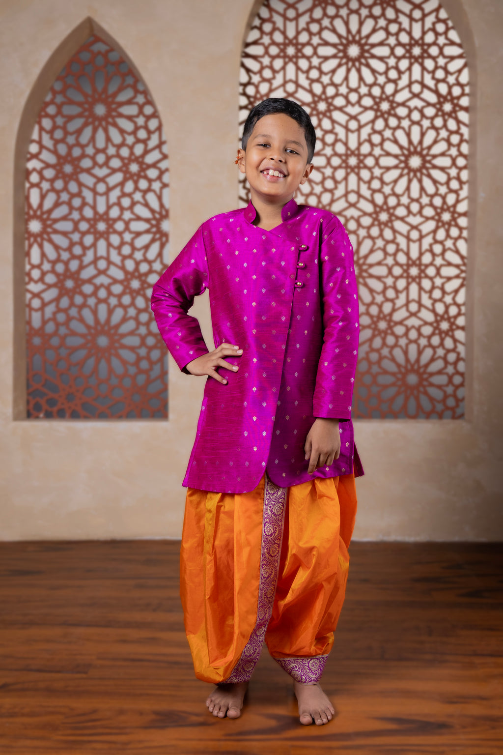 This magenta kurta features a half stand collar and is crafted from raw silk adorned with zari motifs. It showcases an elegant overlap pattern, perfect for Batu occasions.