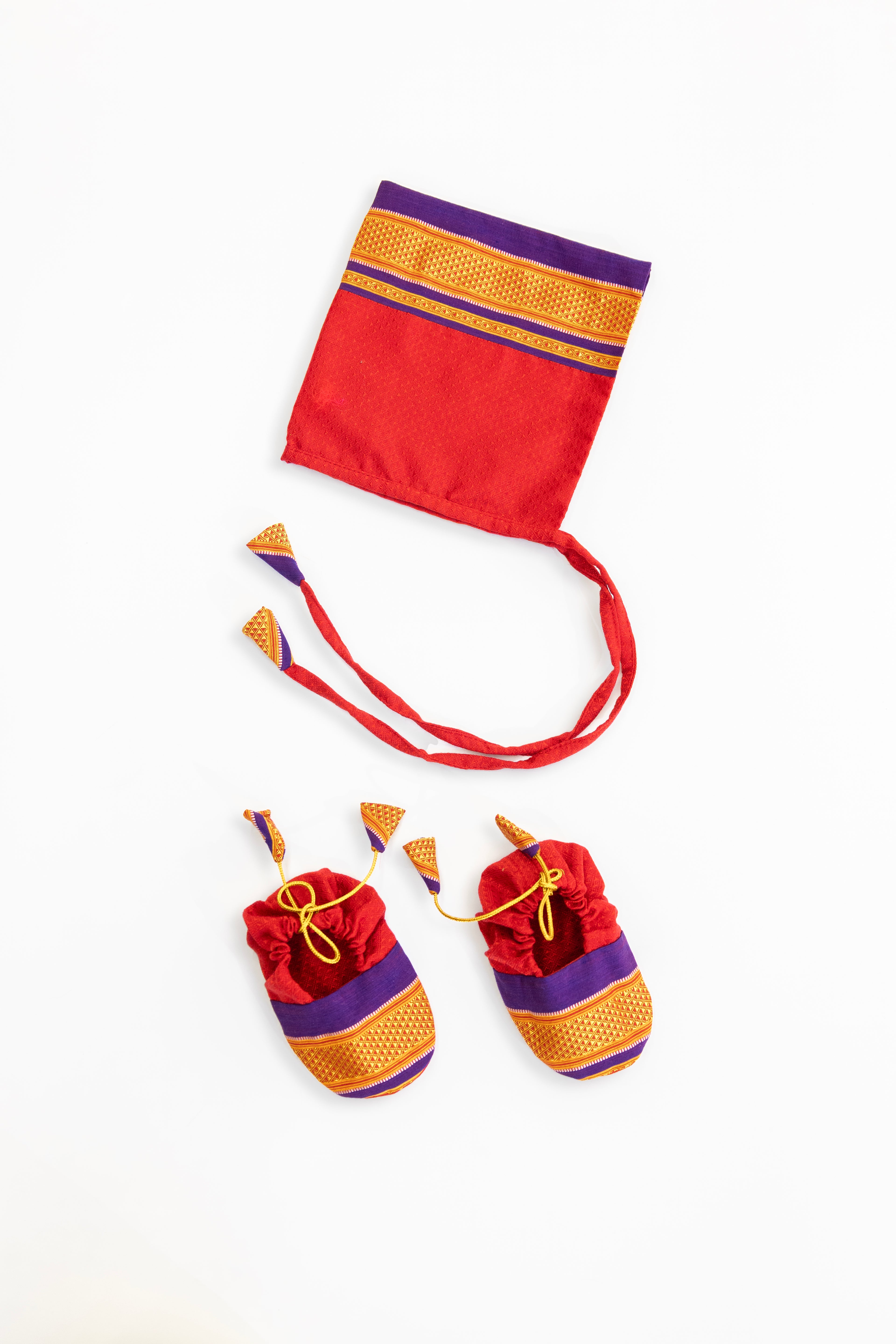 Red handloom khunn with purple border topda / topi/ bonnet with coordinated khunn booties set for NewBorn. Handcrafted accessories for Newborn are perfect add ons to any traditional attire of the baby.Designer baby mats,set of generic bloomers are other naming ceremony essentials.