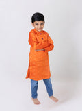This boys' kurta features a vibrant orange taffeta silk fabric with a stand collar and purple fabric buttons. It is lined with cotton inside to ensure added comfort and premium quality.
