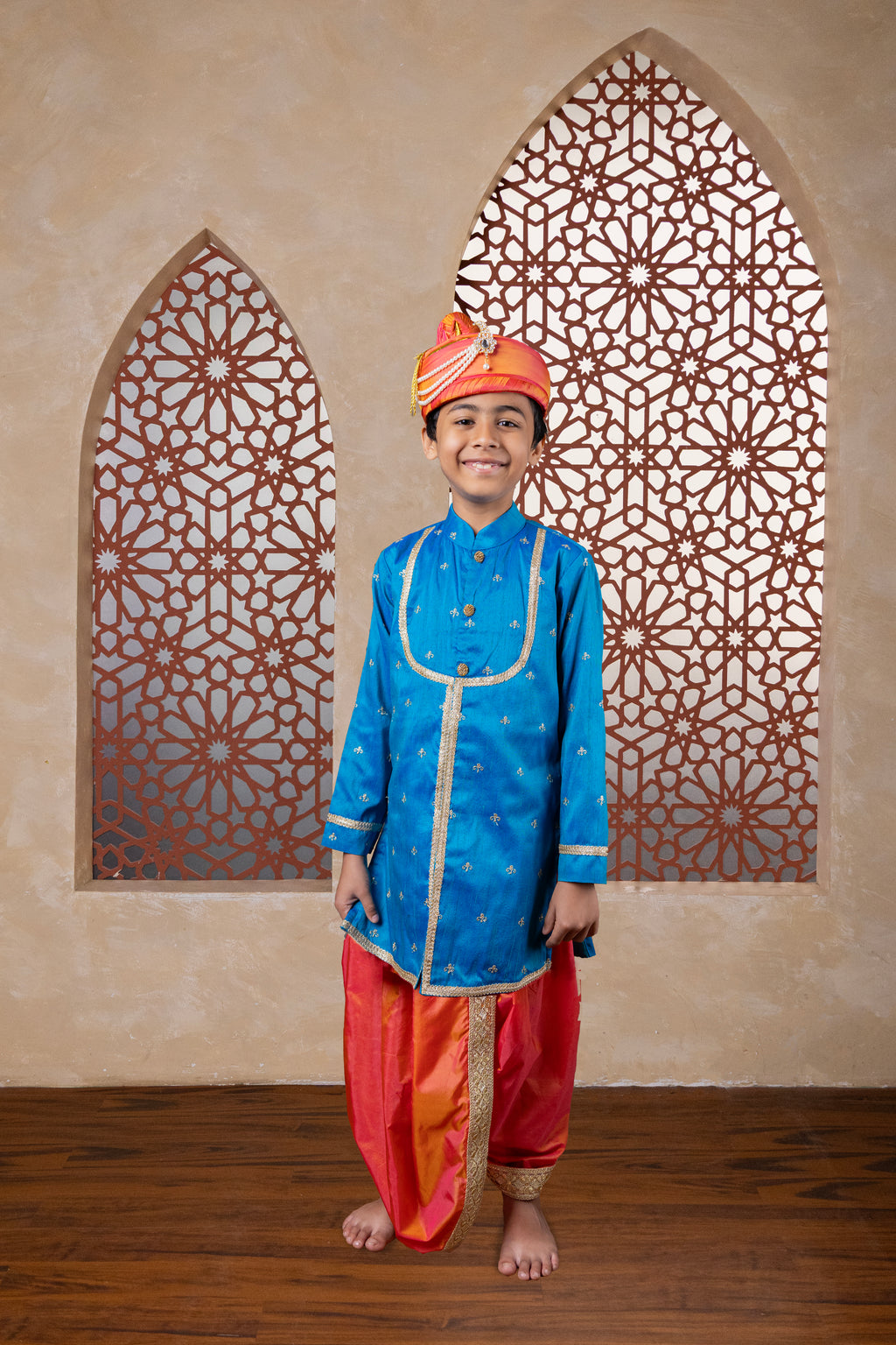 This teal blue raw silk kurta features a detailed yoke design highlighted by intricate all-over zari embroidery. It is elegantly finished with stone-studded buttons for a refined touch.