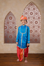 This teal blue raw silk kurta features a detailed yoke design highlighted by intricate all-over zari embroidery. It is elegantly finished with stone-studded buttons for a refined touch.