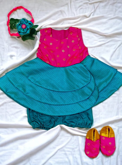 Rani pink with peacock green front open layered dress with coordinated bloomer , headband and booties for a newborn baby girl.