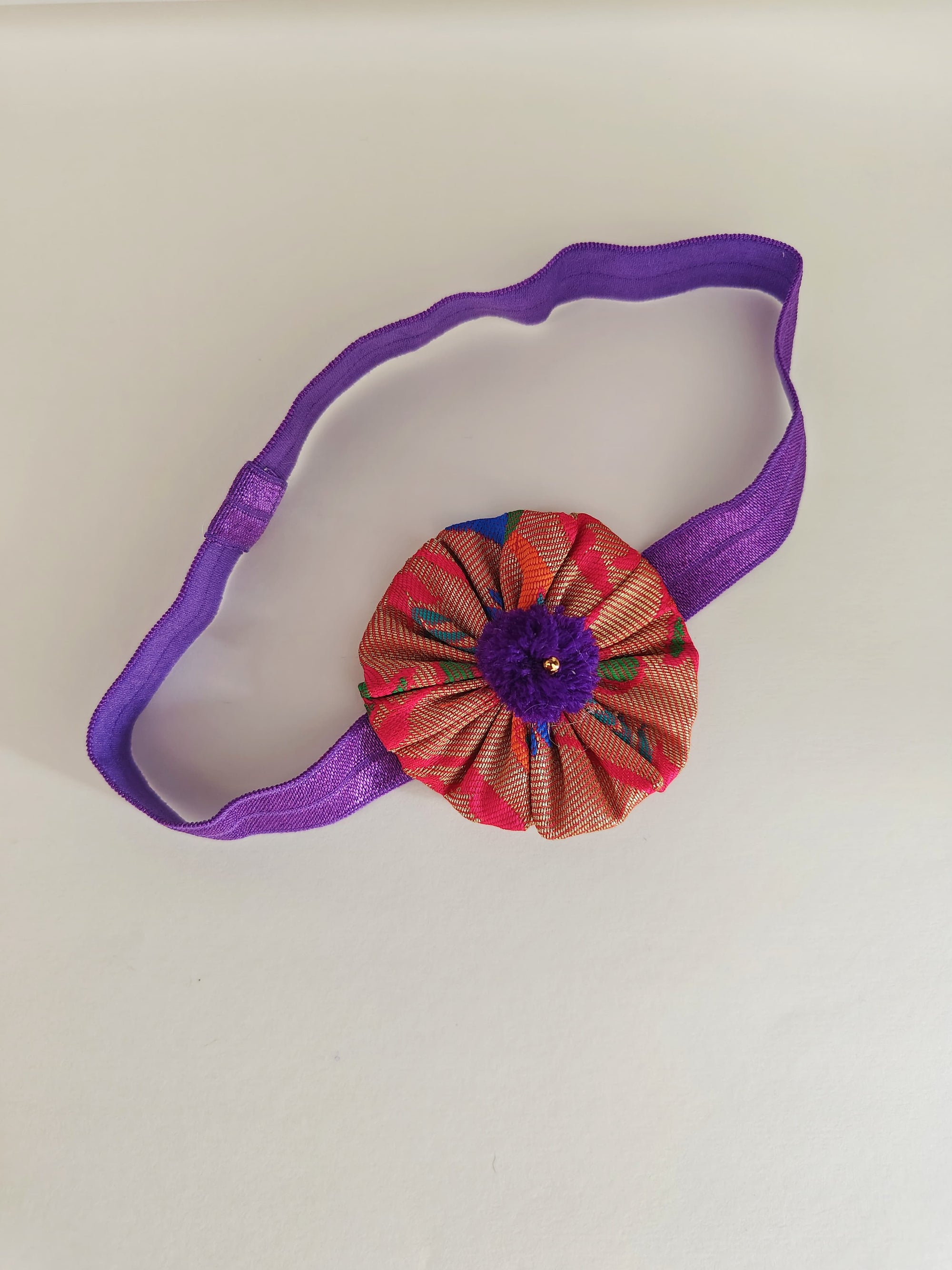 Purple paithani fabric flower elasticated headband for baby girl.