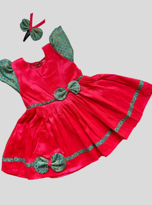 Candy Pink Raw silk dress with sky blue brocade sleeves and bow highlights for Girls.Let your princess be as comfortable as in her casuals with carefully designed & crafted Comfort Ethnic Wear by Soyara Ethnics.Keep her fashion quotient high with timeless patterns, vibrant combinations and royal textiles.
