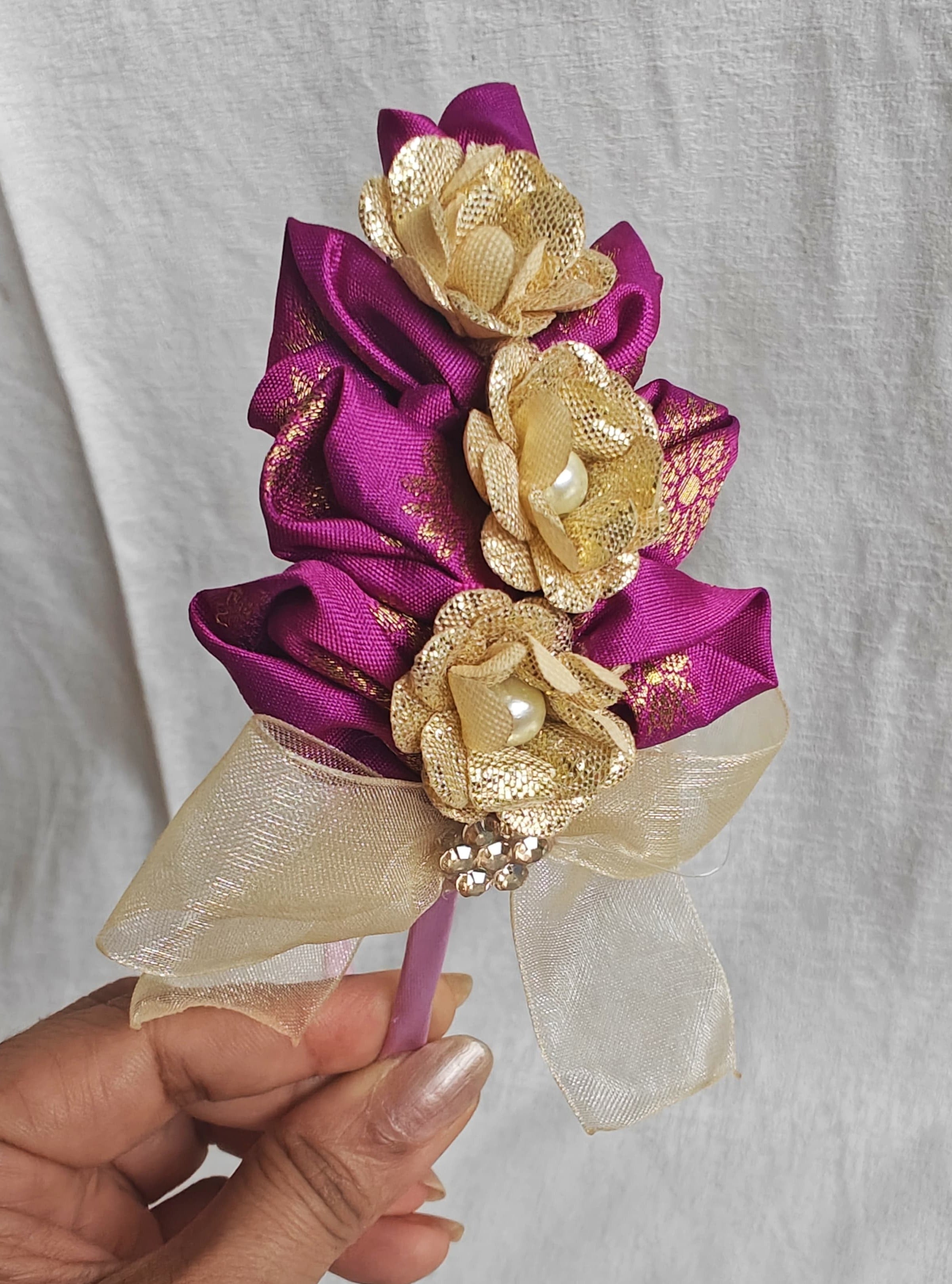 This Magenta flowers with violet headband&nbsp; for girls features delicate fabric flowers and is handcrafted with great care. It is ideal for girls over the age of 2 and makes a lovely addition to any outfit.