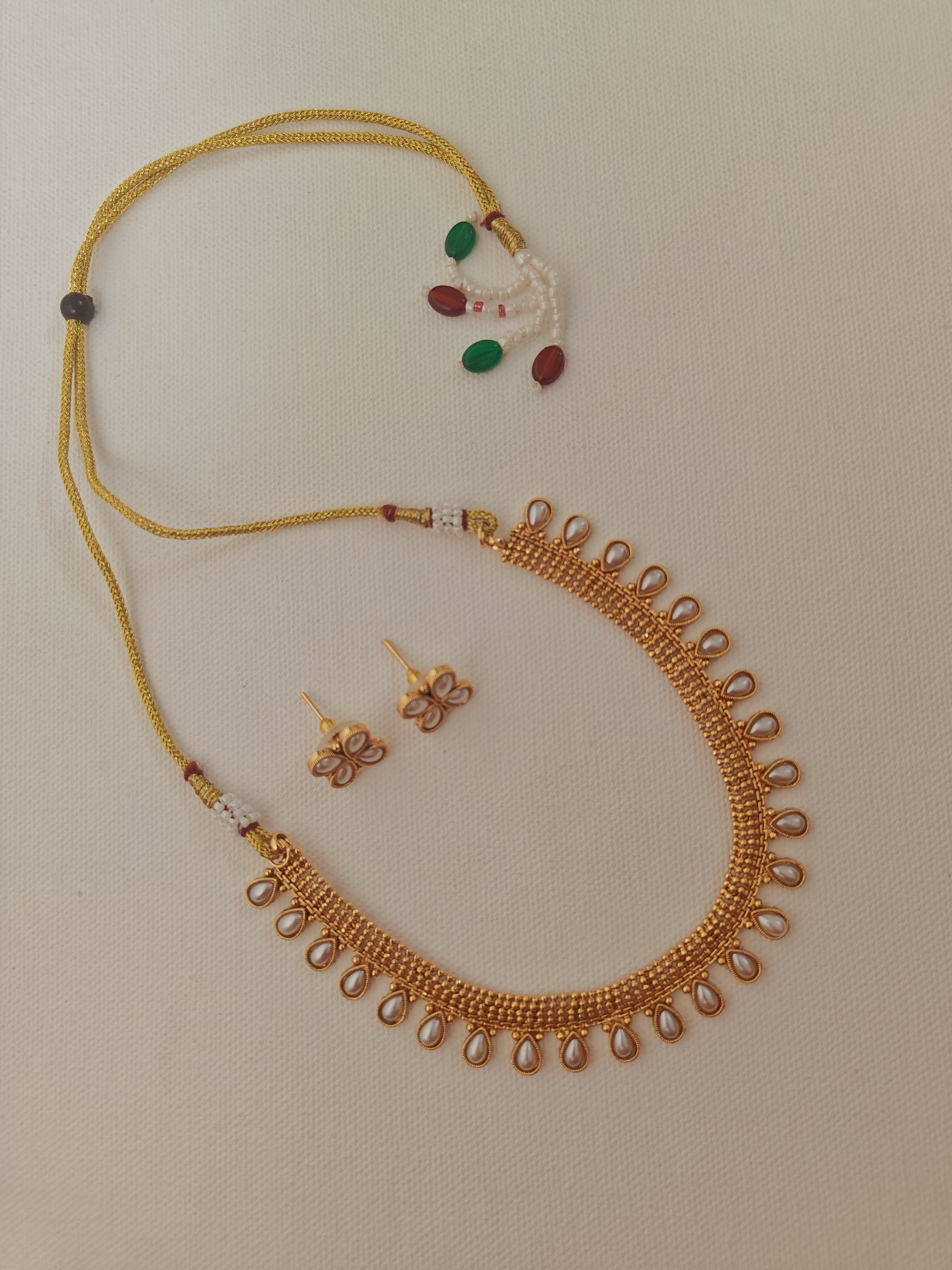 Pearls studded choker with matching earrings for Girls.This set includes a choker and matching earrings with studded pearls, perfect for girls. The drawstring allows for easy length adjustment.