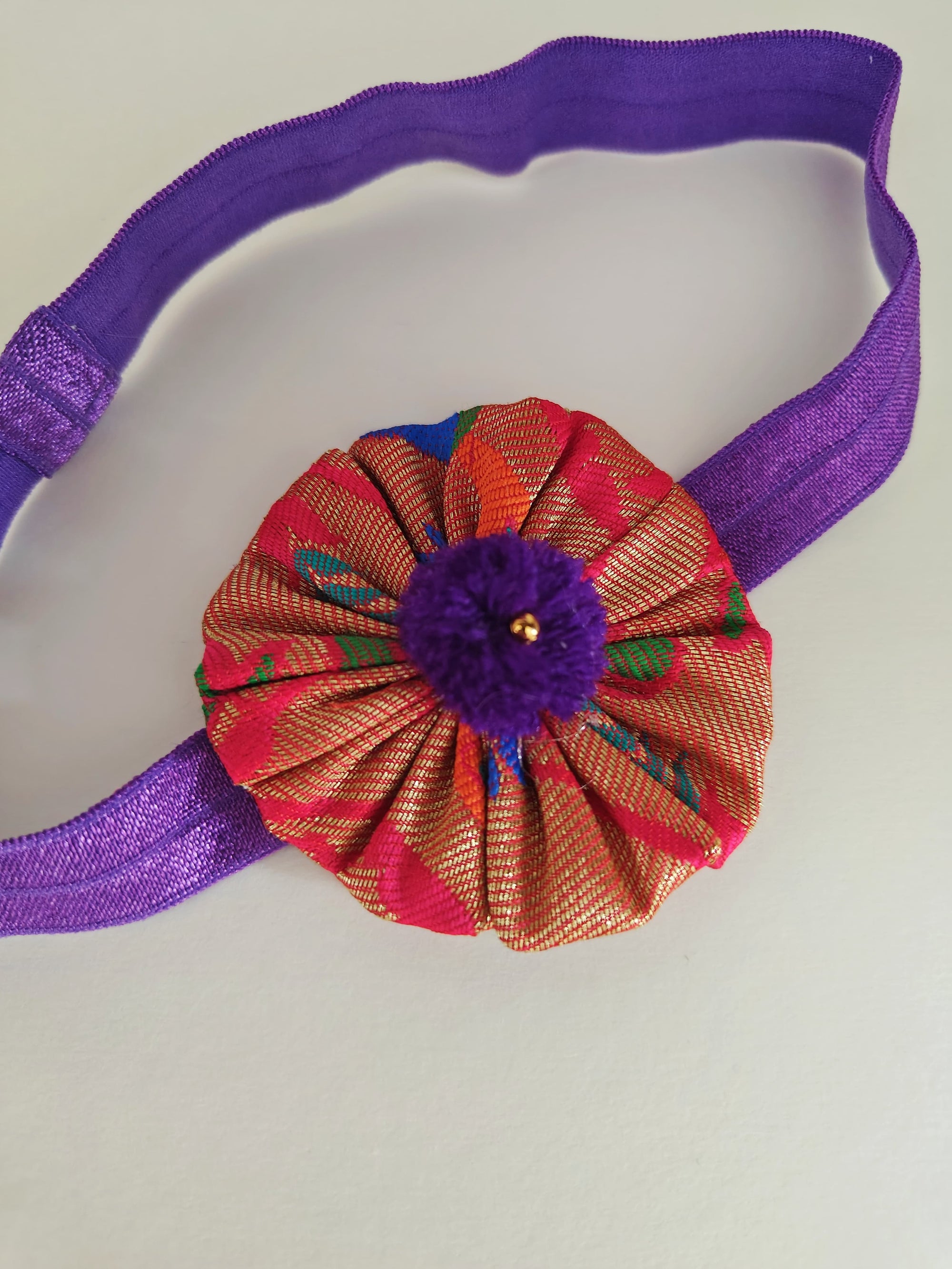 Purple paithani fabric flower elasticated headband for baby girl.