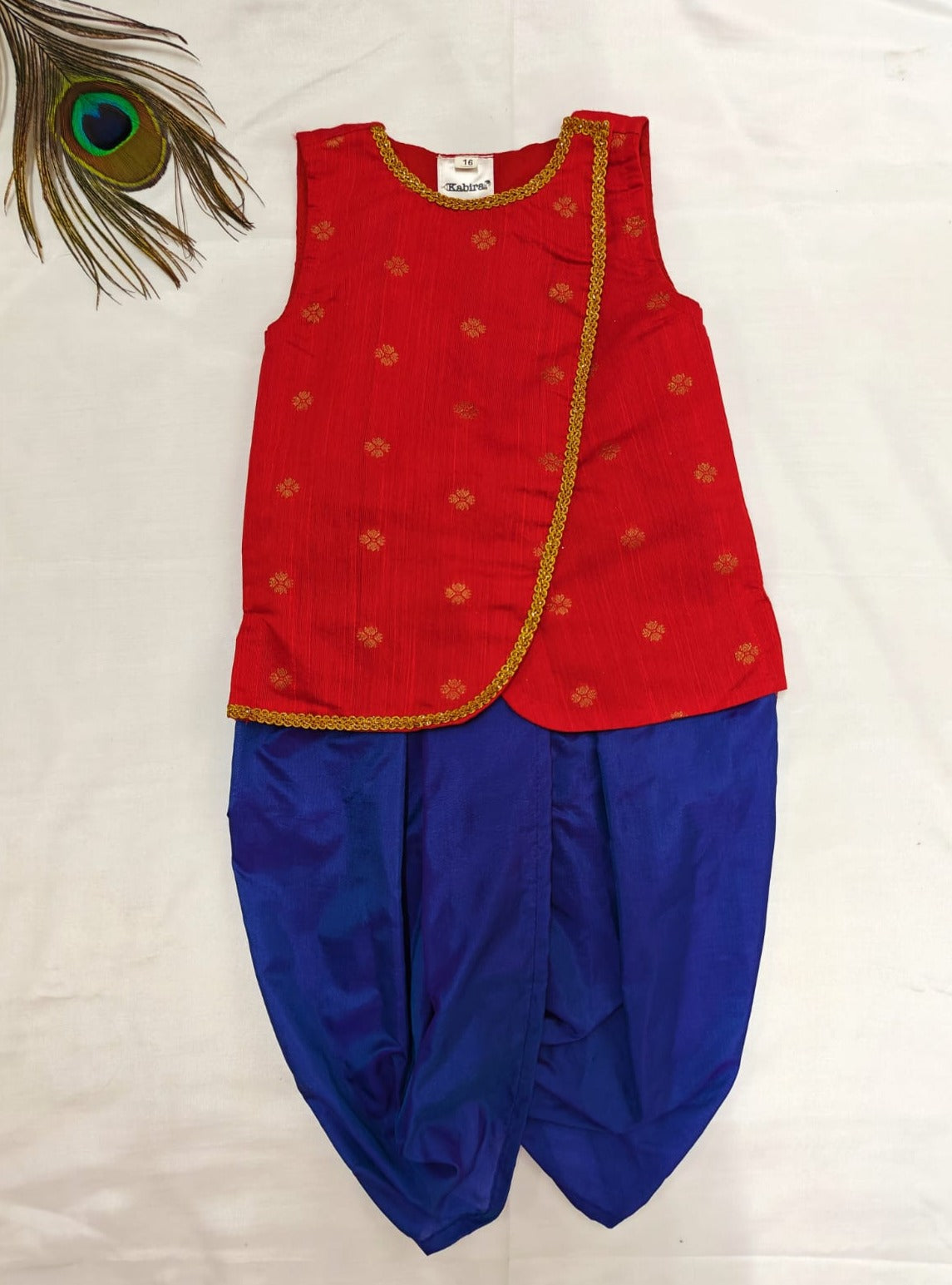 This Kanha set features a royal blue coloured silk Dhoti paired with a front open red sleeveless Kurta. The neck and front opening of the Kurta are adorned with golden lace, making it perfect for both Mundan ceremonies and Janmashtami celebrations.