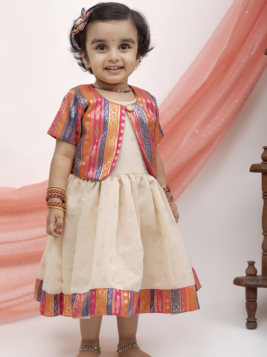 Ivory foil printed Chanderi Frock with banaras silk jacket for Girl.Let your princess be as comfortable as in her casuals with carefully designed & crafted Comfort Ethnic Wear by Soyara Ethnics.Keep her fashion quotient high with timeless patterns, vibrant combinations and royal textiles.