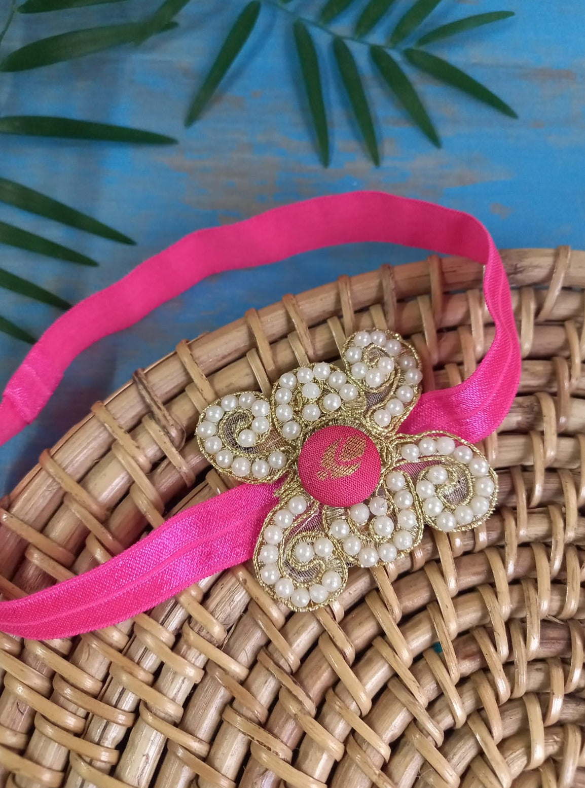 Pearl embellished stretchable Candy Pink headband for a baby. Golden brocade bonnet, paithani booties, cute fabric headbands all these Handcrafted accessories for Newborn are perfect add ons to any traditional attire of the baby. Designer baby mats, set of generic bloomers are the other naming ceremony essentials.