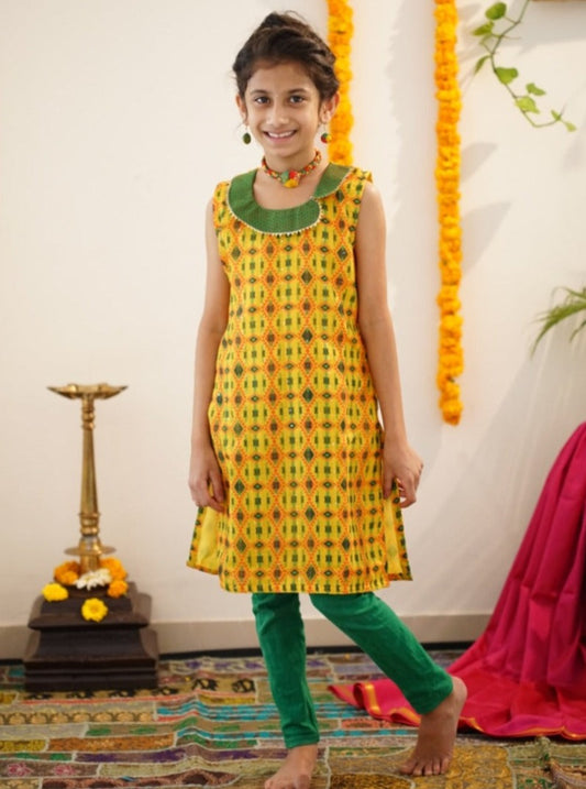 Yellow sequined printed linen kurti with contrast green khunn collar.Let your princess be as comfortable as in her casuals with carefully designed & crafted Comfort Ethnic Wear by Soyara Ethnics.Keep her fashion quotient high with timeless patterns, vibrant combinations and royal textiles.