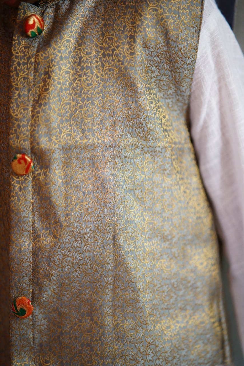 Grey coloured brocade silk stand collar jacket with statement brocade buttons.Cotton lining from inside avoid sweating but give warmth.Statement embellished buttons add royal charm to these jackets. Team these with any plain colored kurta or satin shirt for best festive look!