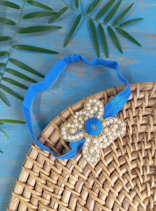 Pearl embellished stretchable Royal Blue headband for a baby. Golden brocade bonnet, paithani booties, cute fabric headbands all these Handcrafted accessories for Newborn are perfect add ons to any traditional attire of the baby. Designer baby mats, set of generic bloomers are the other naming ceremony essentials.