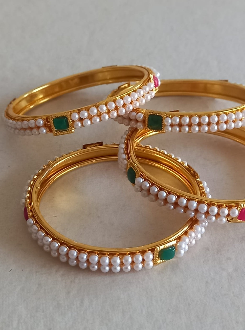 Two layered small pearls lines with square shaped red and green meena work Bangles Set of 4 for Girls.Adorn your princess with head to toe premium quality handcrafted accessories made from allergy free, best quality materials.
