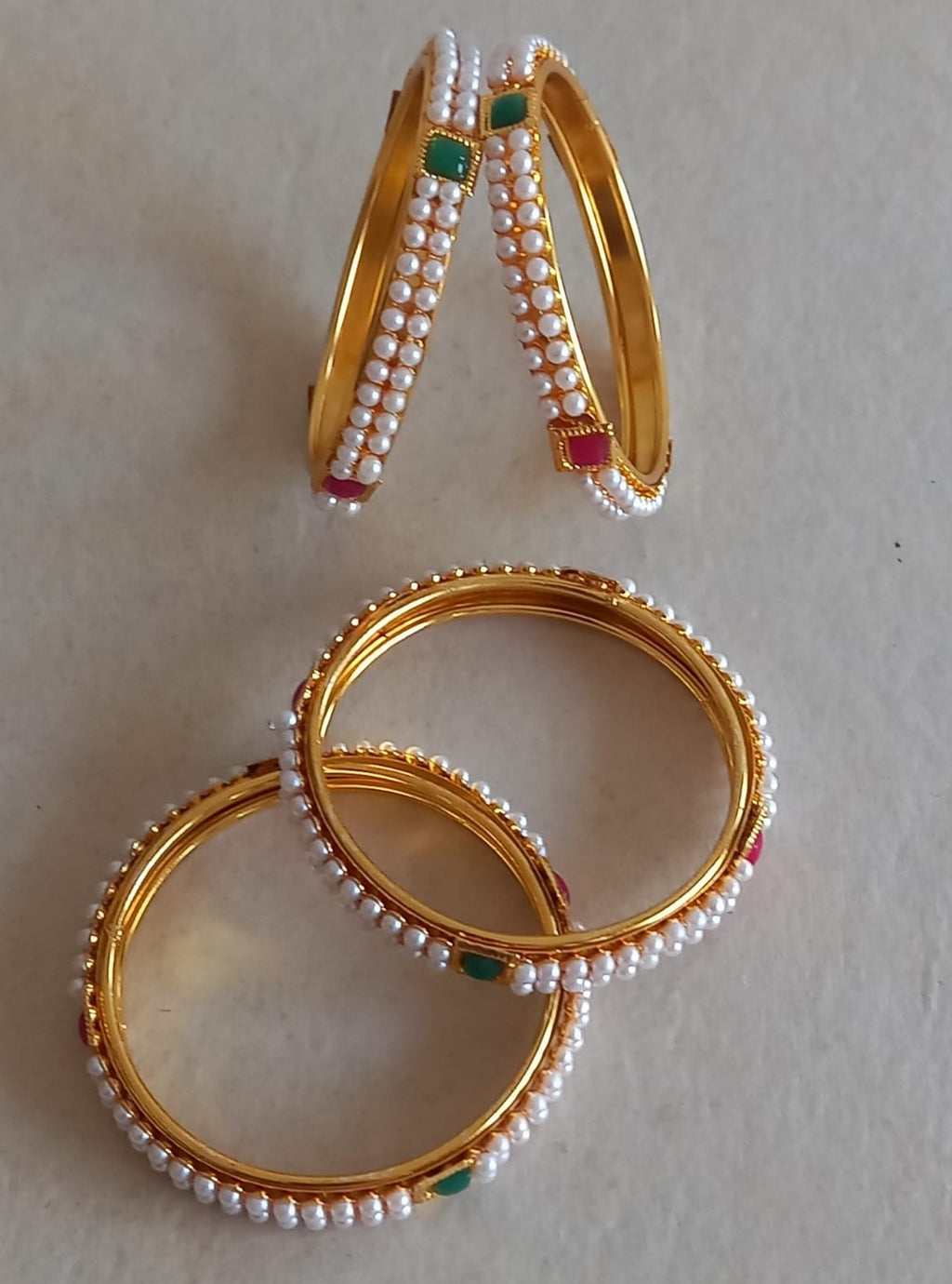 Two layered small pearls lines with square shaped red and green meena work Bangles Set of 4 for Girls.Adorn your princess with head to toe premium quality handcrafted accessories made from allergy free, best quality materials.