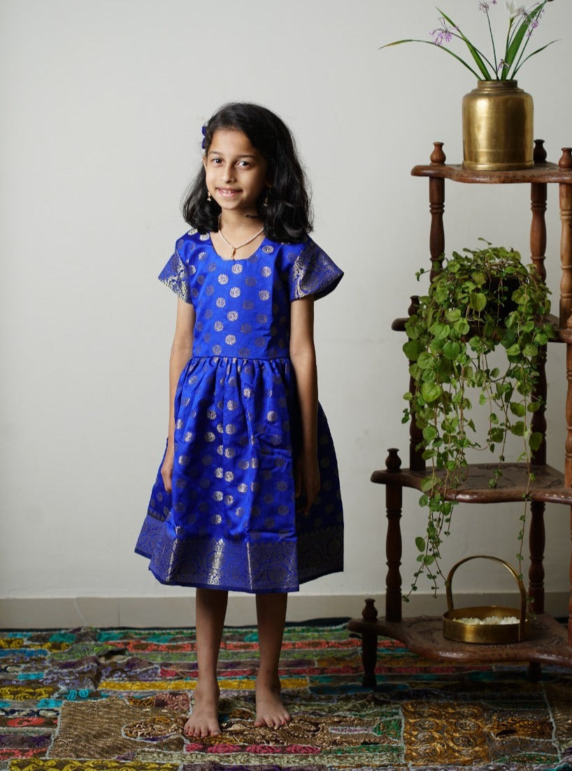Royal blue banarasi brocade dress with woven jari borders for Girls.Let your princess be as comfortable as in her casuals with carefully designed & crafted Comfort Ethnic Wear by Soyara Ethnics.Keep her fashion quotient high with timeless patterns, vibrant combinations and royal textiles.
