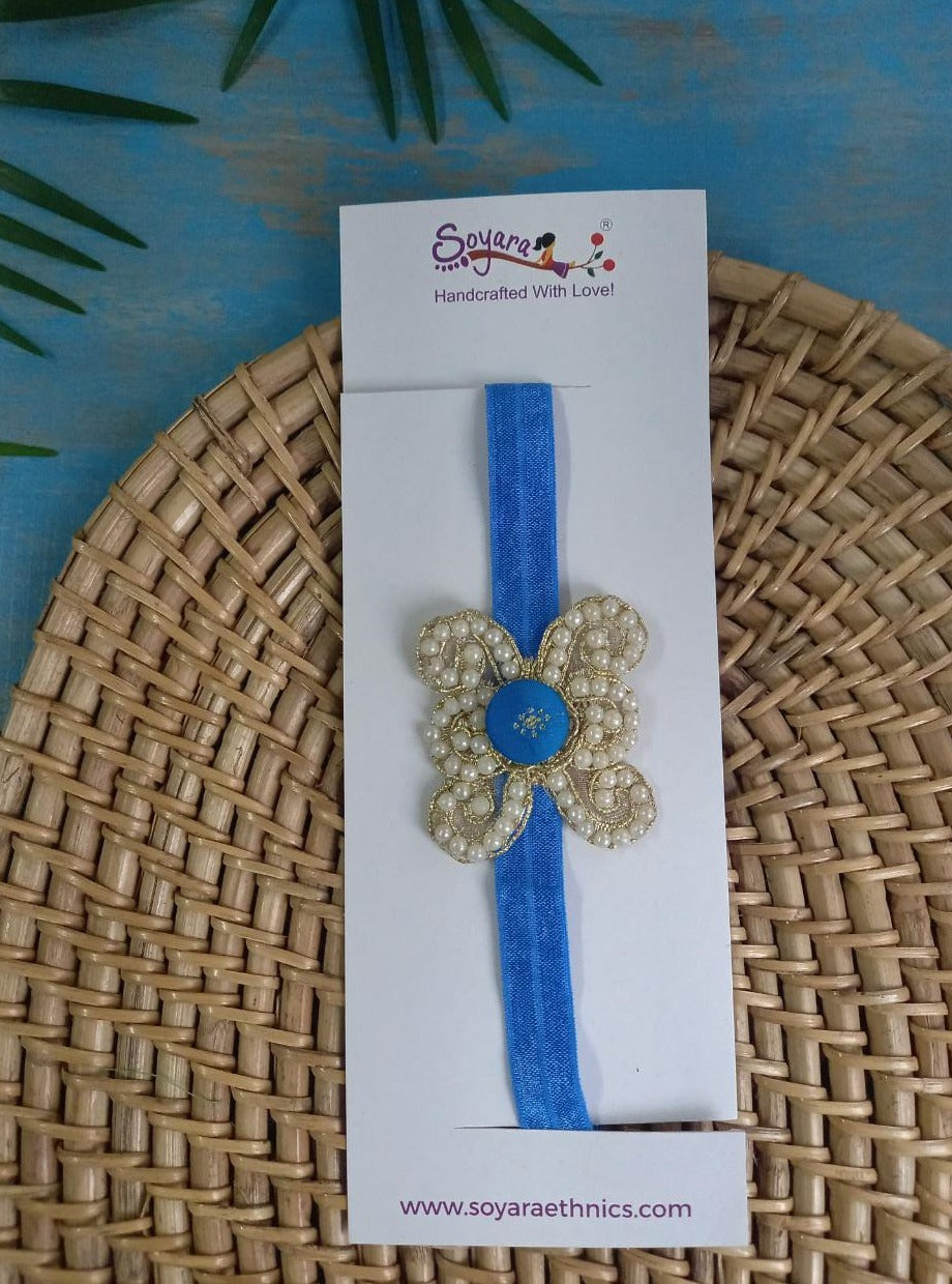 Pearl embellished stretchable Royal Blue headband for a baby. Golden brocade bonnet, paithani booties, cute fabric headbands all these Handcrafted accessories for Newborn are perfect add ons to any traditional attire of the baby. Designer baby mats, set of generic bloomers are the other naming ceremony essentials.