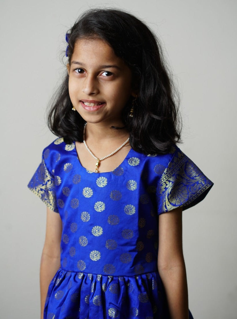 Royal blue banarasi brocade dress with woven jari borders for Girls.Let your princess be as comfortable as in her casuals with carefully designed & crafted Comfort Ethnic Wear by Soyara Ethnics.Keep her fashion quotient high with timeless patterns, vibrant combinations and royal textiles.