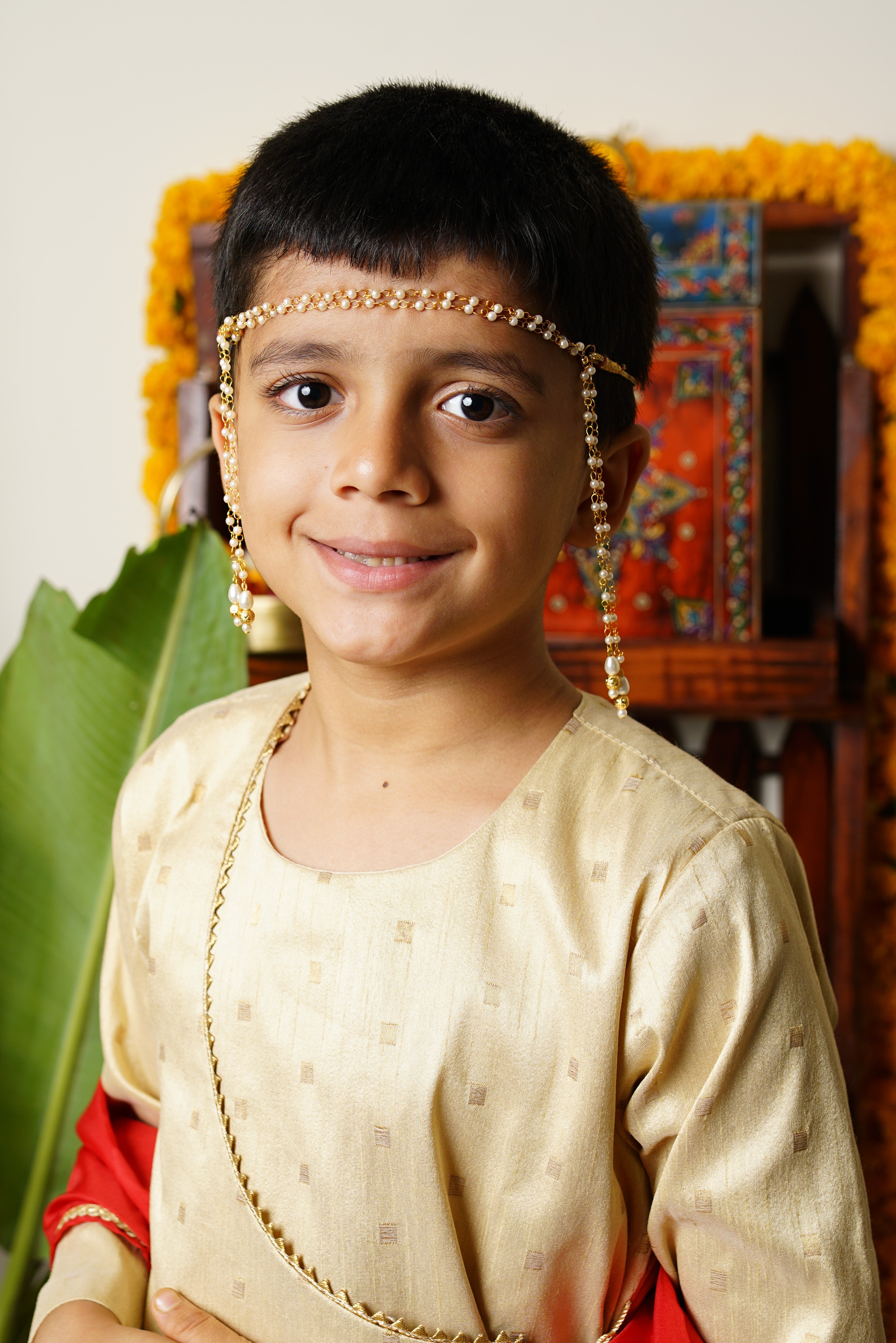 Mundavalya is a forehead ornament worn by Batu for Vratabandh/Munj/Upnayan/ Thread Ceremony.It is designed in pearls Golden Findings.Mundavalya,kanthi,bhikbali,topi,pagdi are boys accessories exclusively designed using Pearls,glass beads,jadau & gold plated findings for Batu,for Upanayan/Vratabandha/munj /thread ceremony.