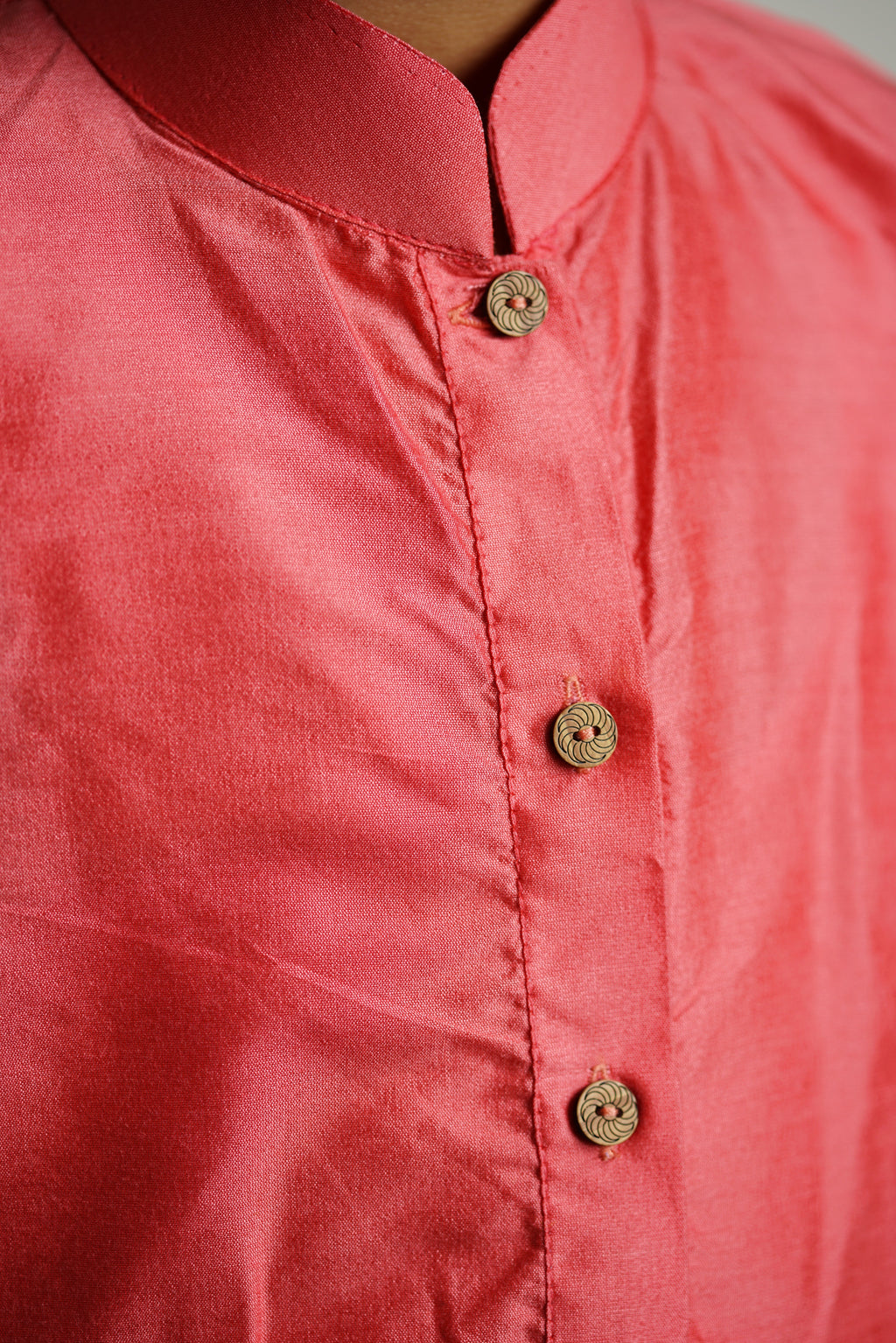 Carrot Pink cotton silk stand collar long kurta with wooden buttons.Kurtas with collar or Angrakha pattern teamed with salwar are the best choice for any festive occasion for boys.They are Trendy, Easy to wear and comfortable to carry.