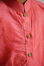 Carrot Pink cotton silk stand collar long kurta with wooden buttons.Kurtas with collar or Angrakha pattern teamed with salwar are the best choice for any festive occasion for boys.They are Trendy, Easy to wear and comfortable to carry.