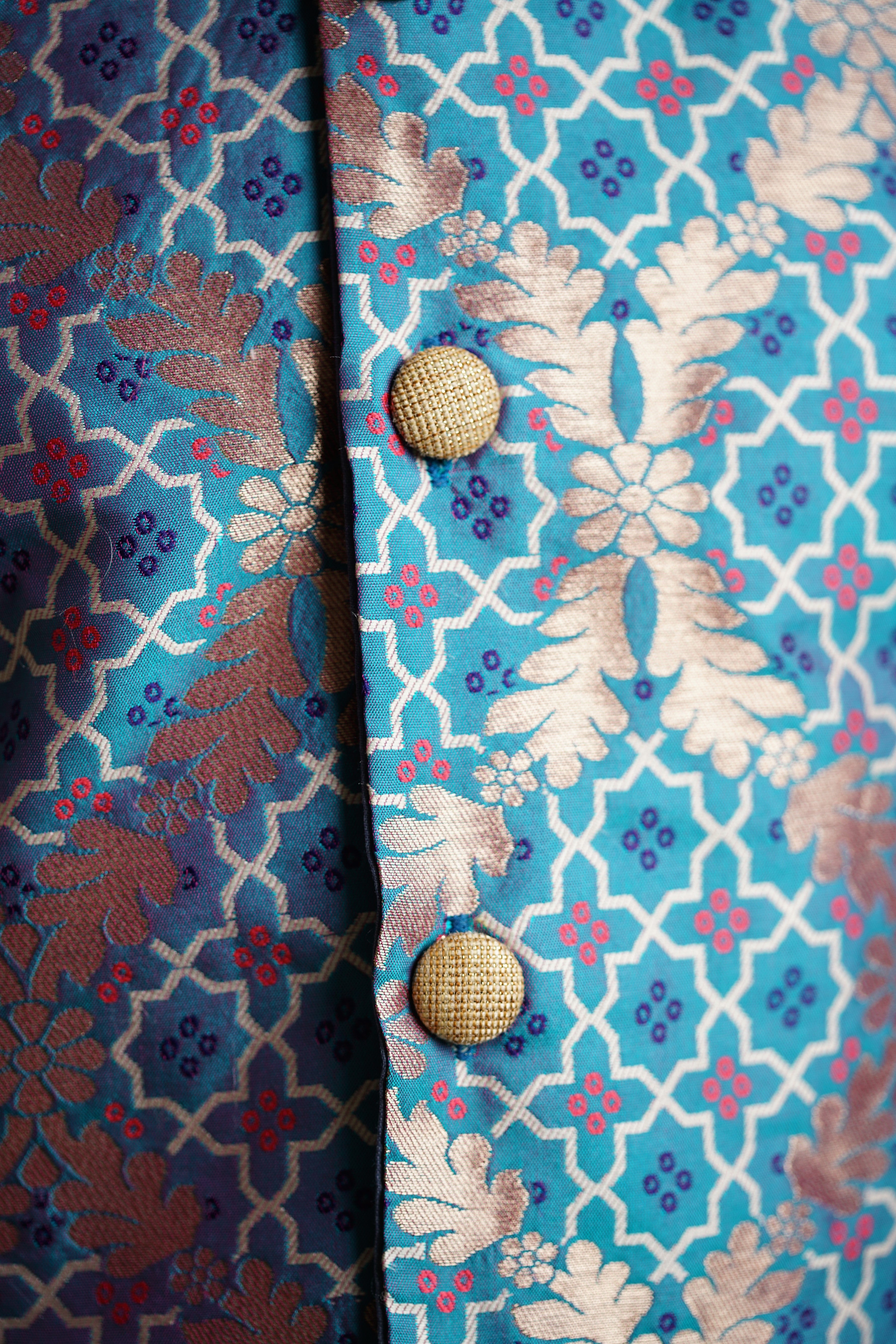 Aqua blue Brocade jacket with multicolored bandhani design .Cotton lining from inside avoid sweating but give warmth.Statement embellished buttons add royal charm to these jackets. Team these with any plain colored kurta or satin shirt for best festive look!