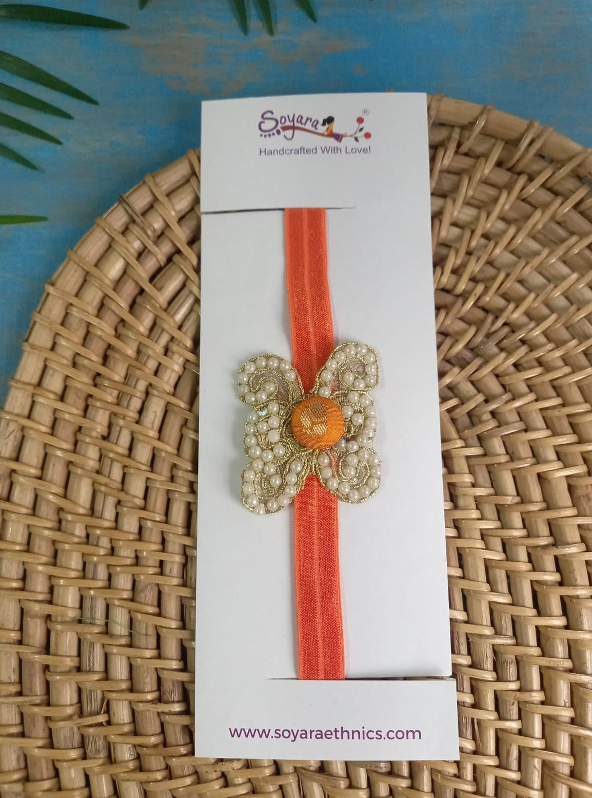 Pearl embellished stretchable Orange headband for a baby. Golden brocade bonnet, paithani booties, cute fabric headbands all these Handcrafted accessories for Newborn are perfect add ons to any traditional attire of the baby. Designer baby mats, set of generic bloomers are the other naming ceremony essentials.